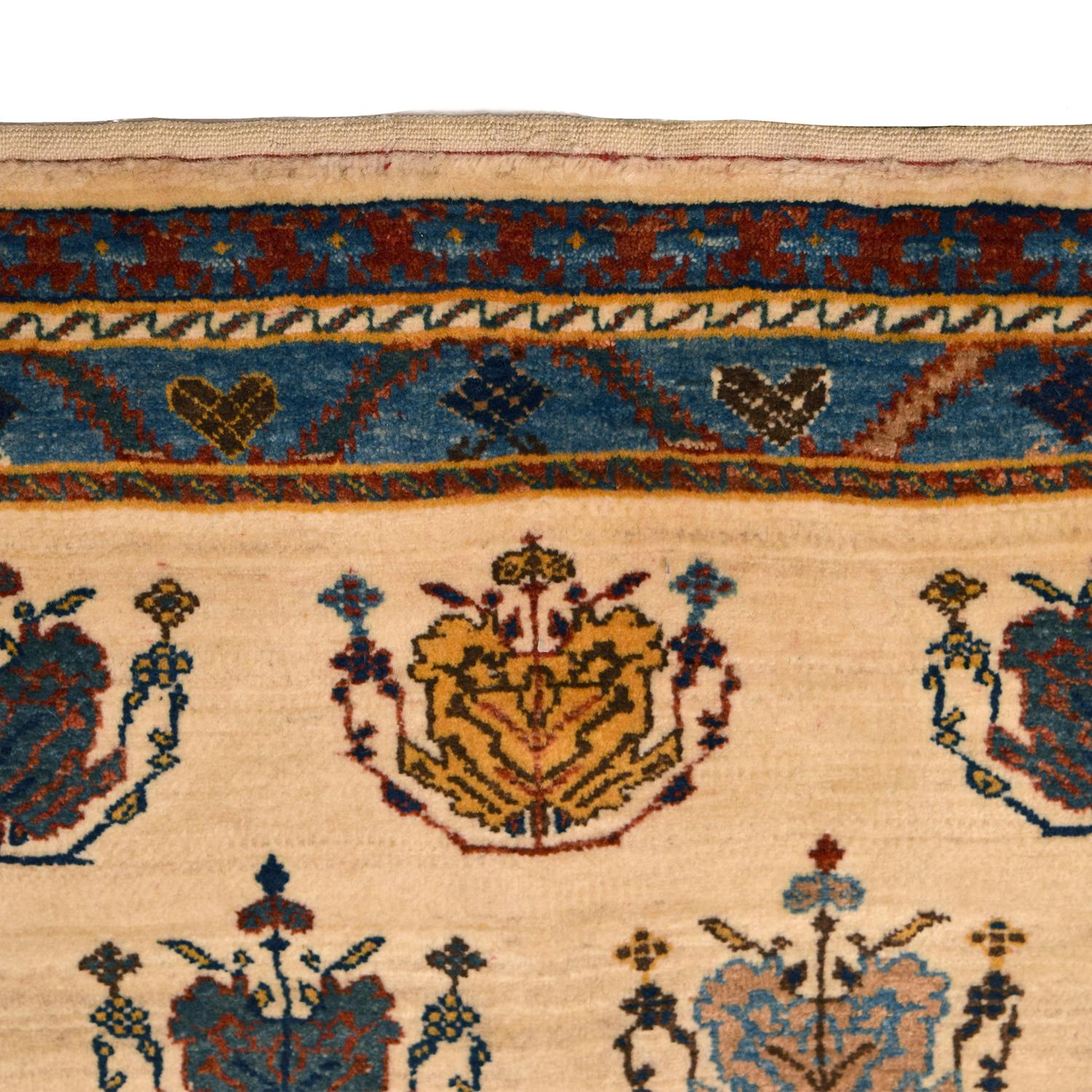 Utilizing cream and blue tones to create a peaceful and inviting pattern, this vintage Persian Kashkouli carpet is hand-knotted and measures 3’9” x 5’8”. To obtain these bright shades of gold, red, blue, and green wool, the weaver utilized organic