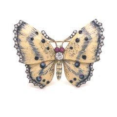 Broche papillon en émail crème et bleu et diamants