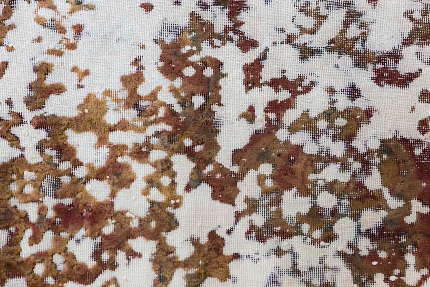 Ancien tapis persan rectangulaire dans les tons marron et rouge avec des motifs stylisés sur les côtés et un fond crème.
Texture de la moquette obtenue grâce au travail contemporain d'un artiste par tonte, grattage et teinture.

Pièce unique.