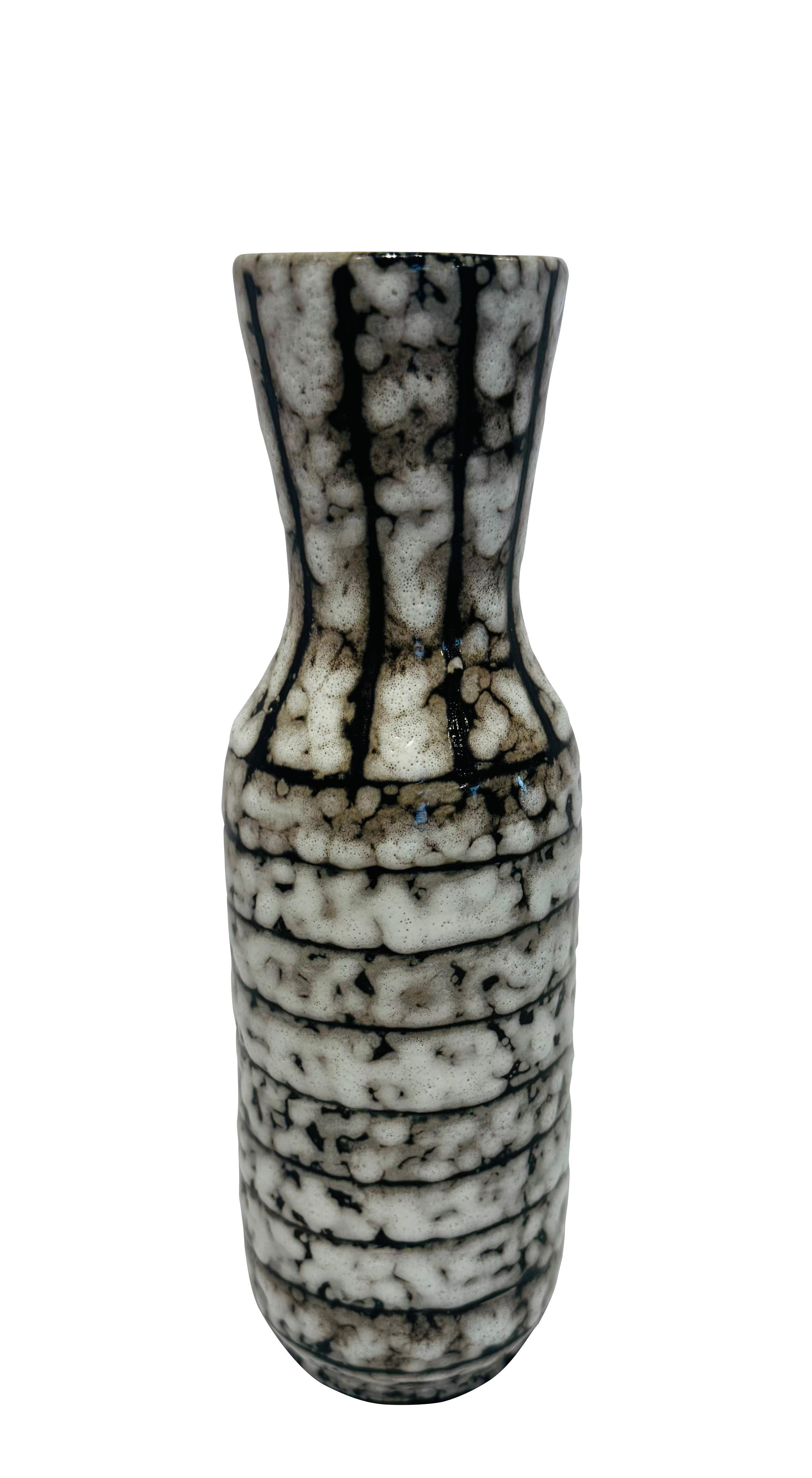 Vase en céramique hongroise crème et marron des années 1940.
Glaçure intérieure bleu cobalt.
Texture générale des fossettes.
Rayures verticales sur le dessus.
Bande horizontale à la base.
Fait partie d'une grande collection.