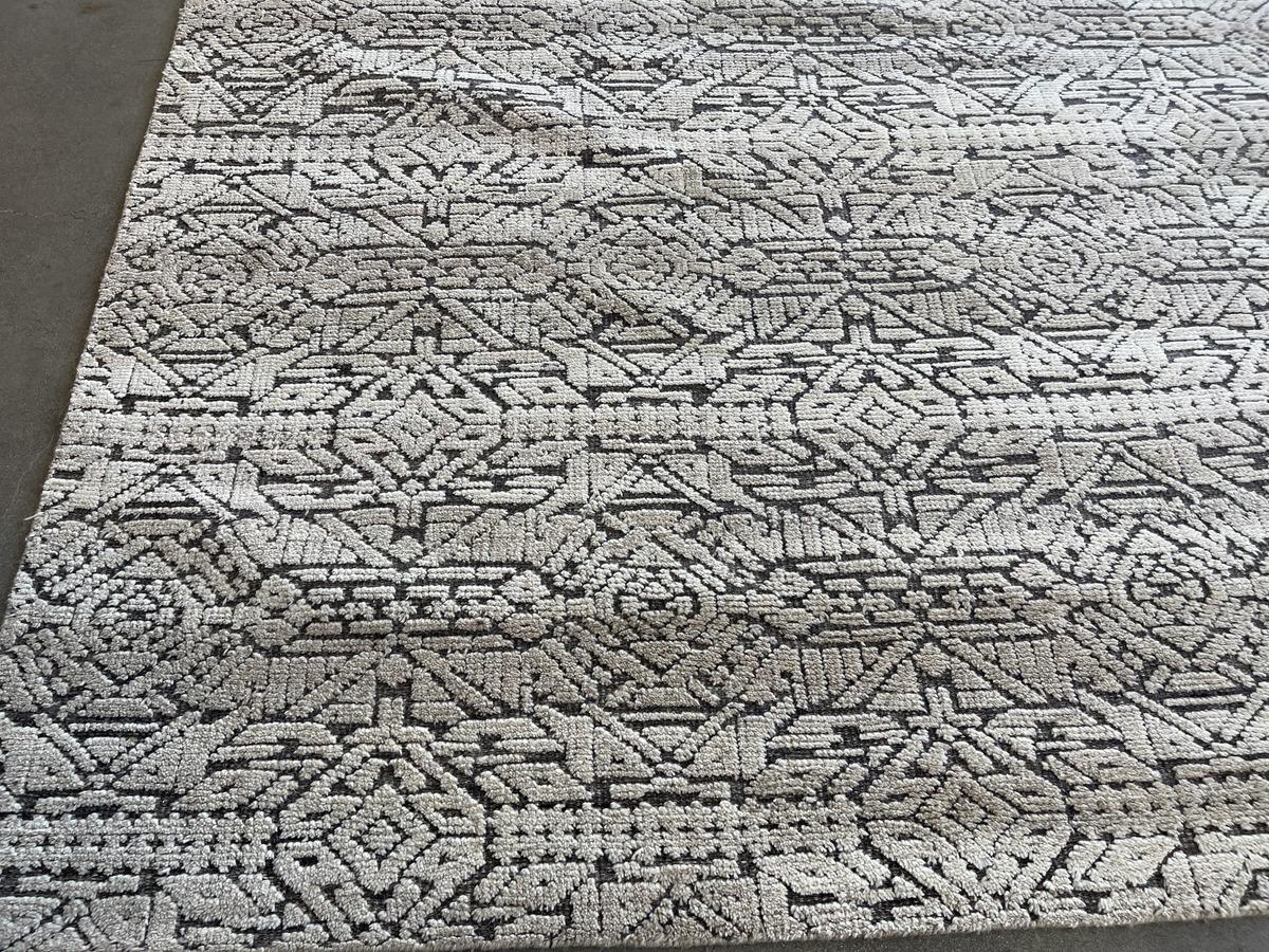 From the Mystique Collection comes this stunning area rug created by a complex pattern of cut fibers and exposed woven base. The result is a piece that will add another level of visual excitement to a space without being distracting. Neutral tones