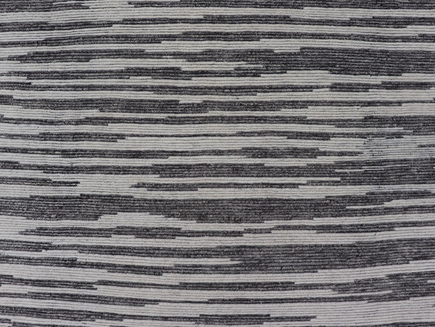  This oversized Indian Modern casual features an unusual, half-geometric half-abstract horizontal stripes that resemble that of a wood grain pattern. With no clear differentiation between the background and foreground, this piece is rendered in
