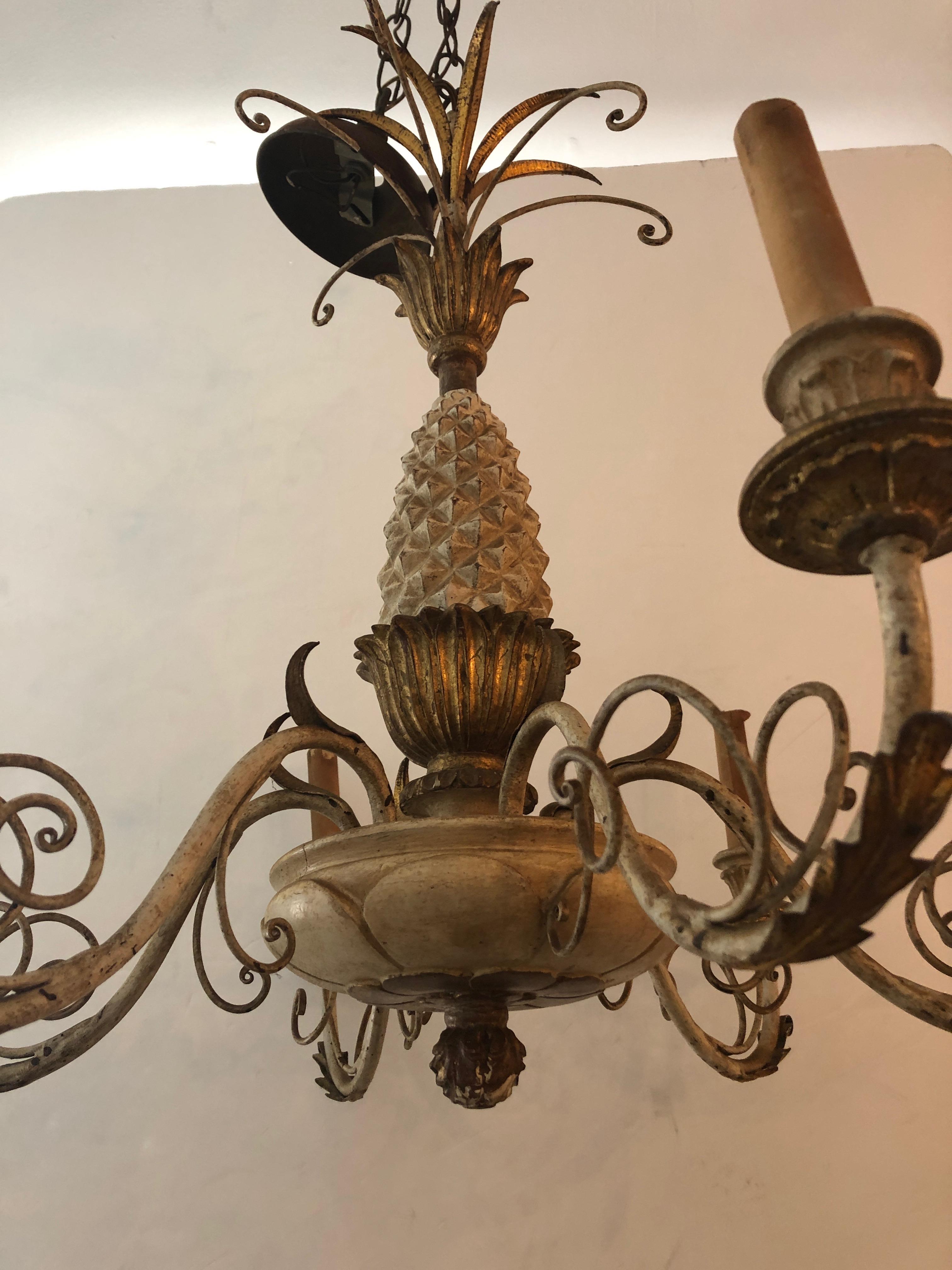 A classically elegant off-white and gold pineapple motif Italian chandelier of carved wood, iron and tole having 6 arms and wonderful details from top to bottom. Comes with ceiling CAP.