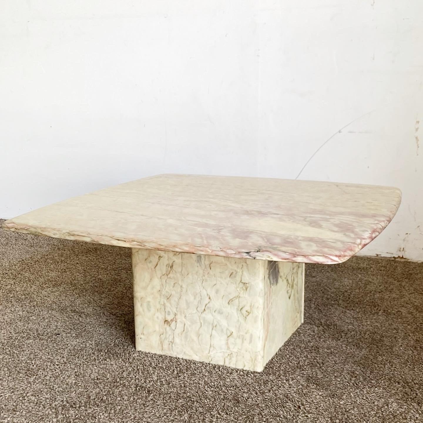 Enhance your living room's ambiance with the Cream and Pink Marble Coffee Table. Featuring a unique rounded square top, this exceptional piece not only serves as a functional table but also showcases the natural beauty and intricate veining of