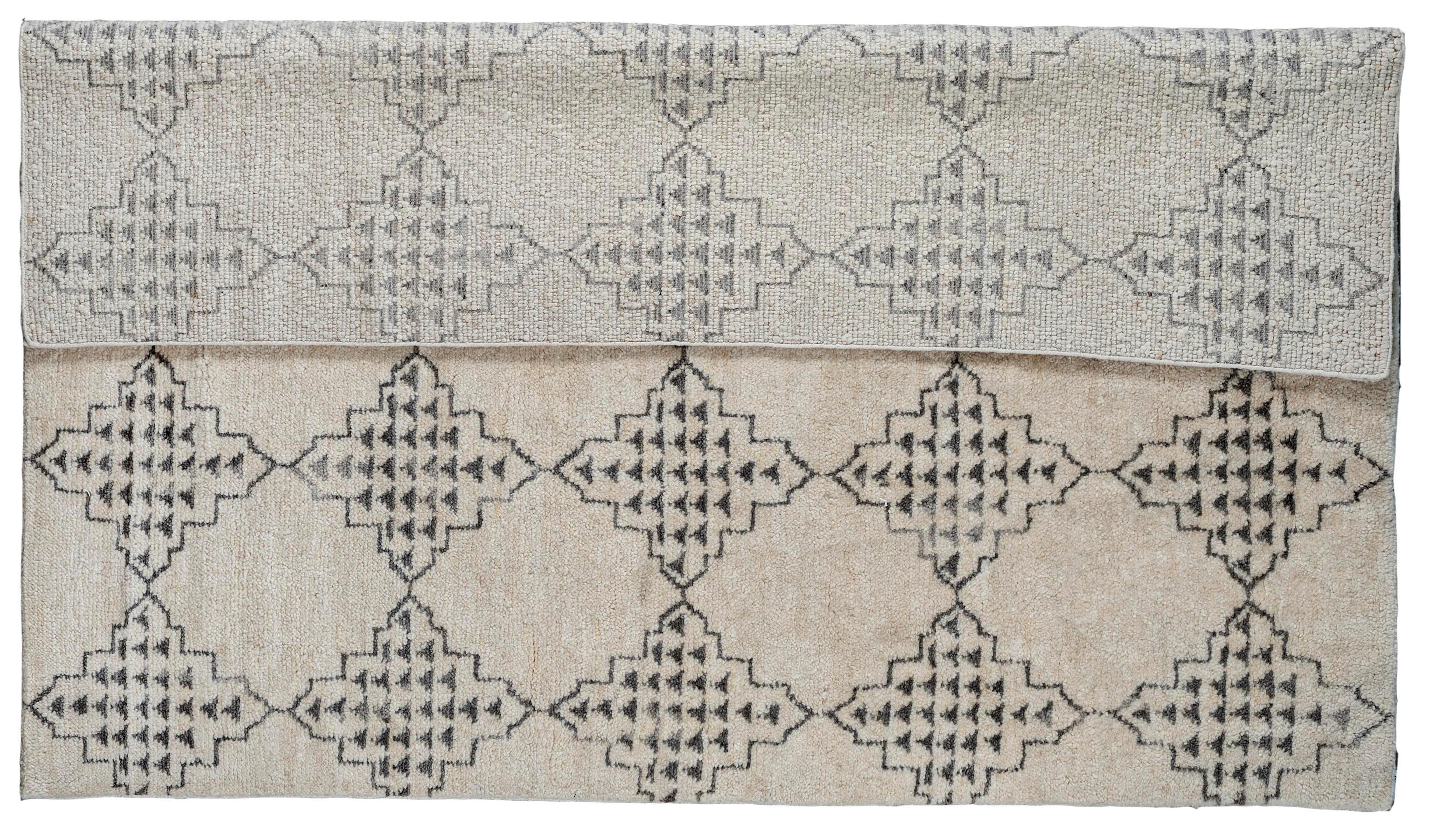 Coming from our newest collection of Moroccan designs, this 8x10 cream and silver diamond design area rug is handmade and hand-knotted made in India. It has a cotton base and is made from all wool yarns. It features a contemporary composition of all