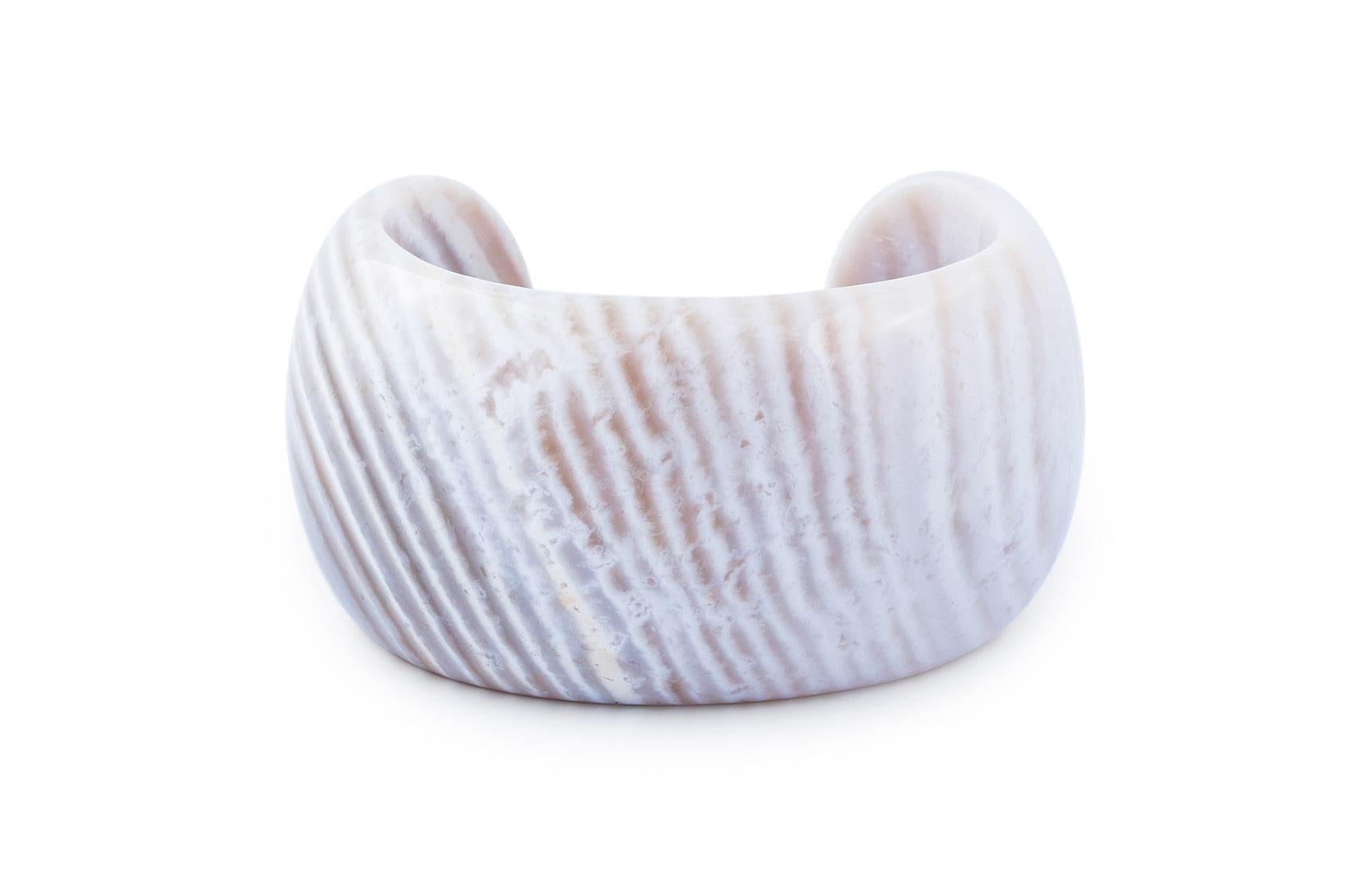 La manchette Cream Arm Laura est une pièce étonnante qui allie un design minimaliste à l'élégance naturelle de la calcédoine. Réalisée avec une pierre de calcédoine lisse et crémeuse, cette manchette entoure le bras d'une manière élégante et