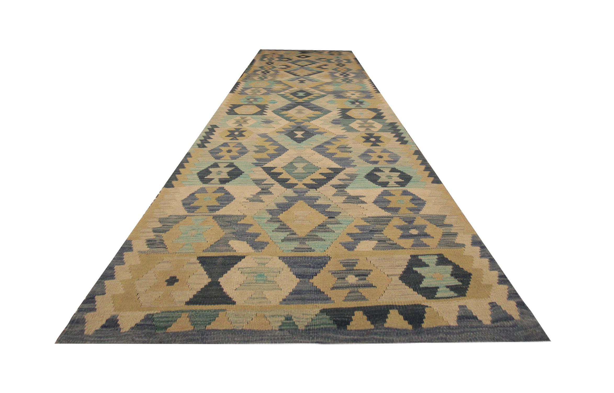 This fine wool kilim rug was woven by hand in Afghanistan in the early 21st century. The design features a bold geometric pattern woven in a repeating design, displaying a rich colour palette including cream, blue and beige. The colour and design in