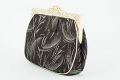 Cream carved Bakelite frame and patterned silk clutch bag, English, 1920s