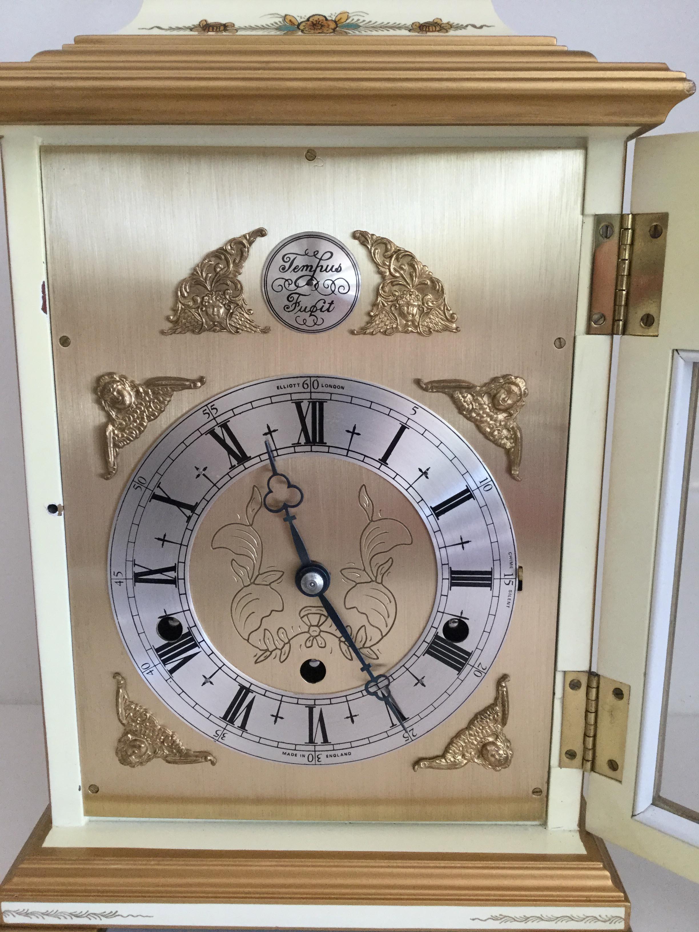 A beautiful cream chinoiserie decorated three train mantel clock by makers Elliott of London. The case profusely decorated with garden scenes, maidens, pagodas and floral motifs, the brass dial with angel spandrels and silver chapter ring with roman