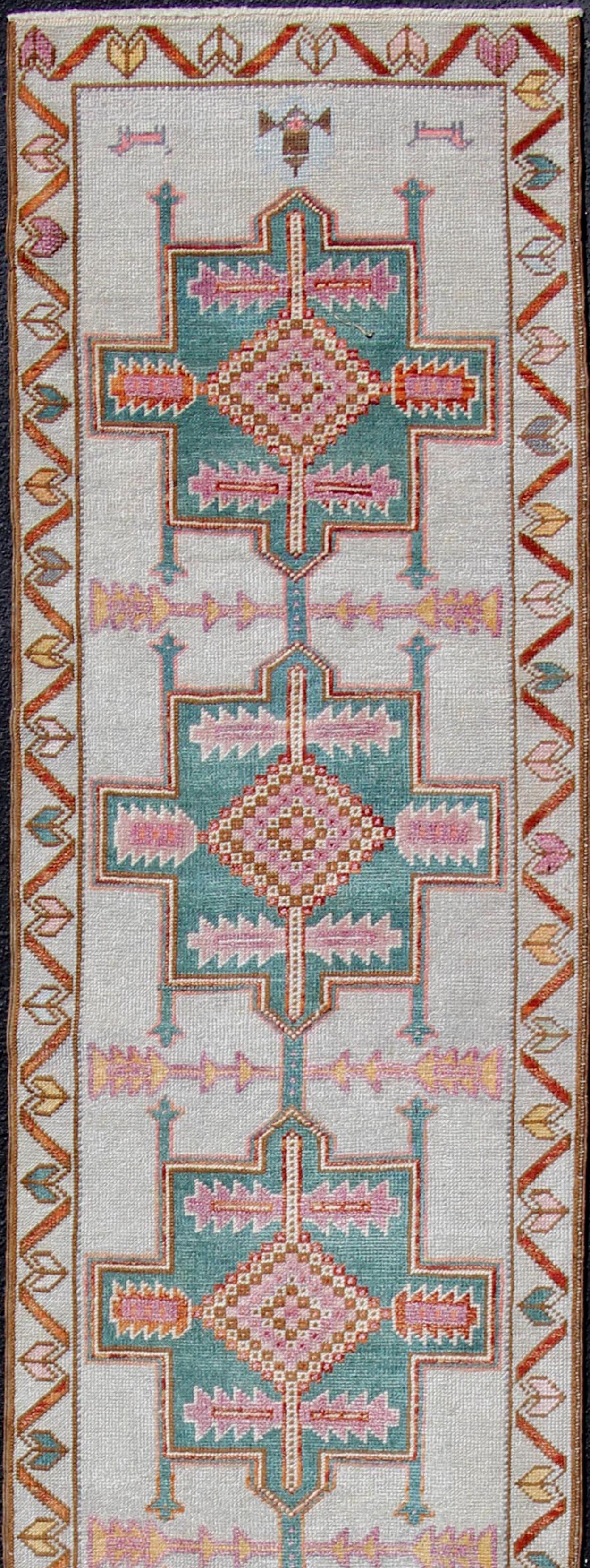 Colorful vintage Turkish oushak runner with repeating medallion geometric design in teal color design and cream background, rug/EN-179543, Keivan Woven Arts / country of origin / type: Turkey / Oushak, circa 1950

This vintage Oushak runner (circa