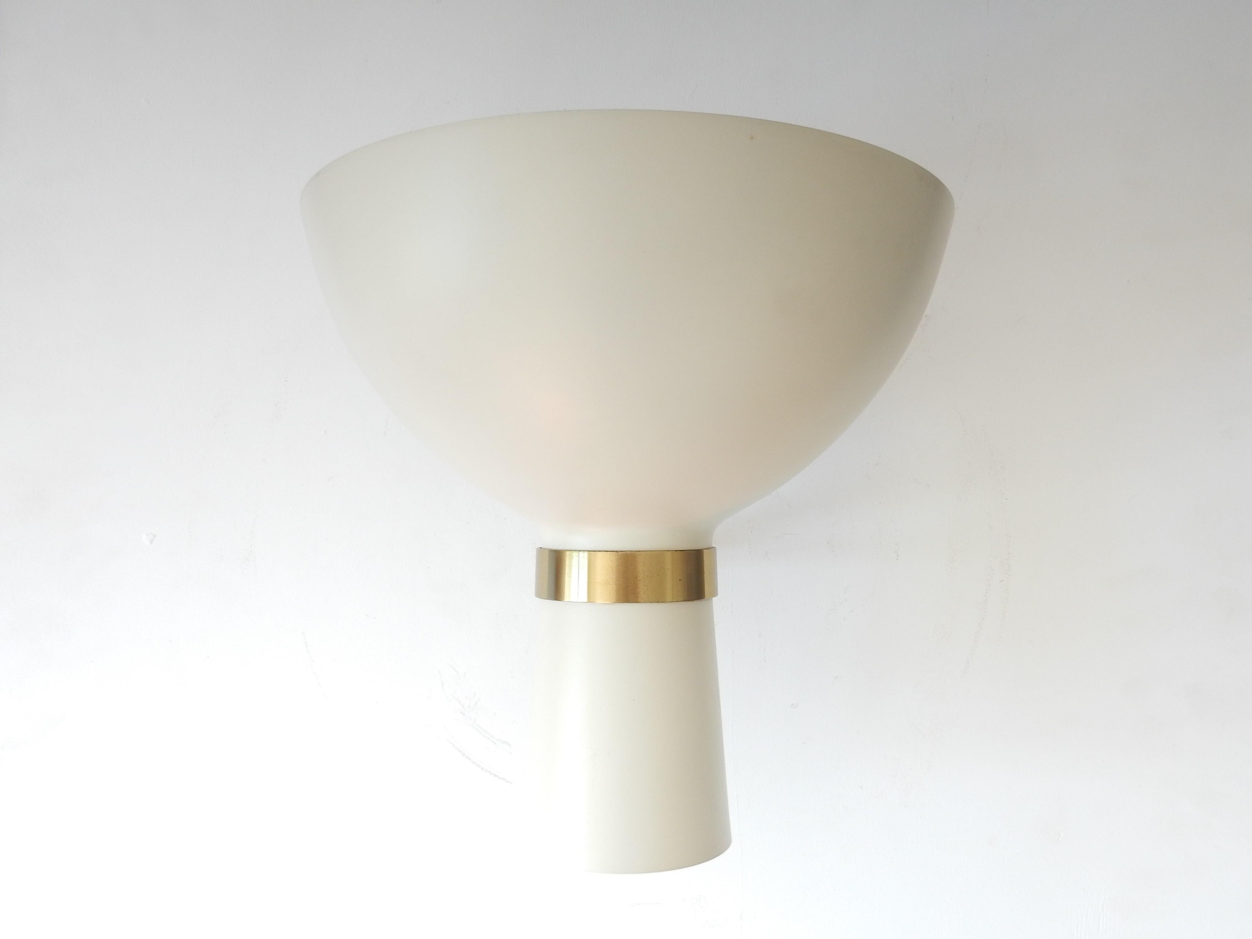 This amazing wall lamp in diabolo shape is often attributed to Stilnovo from Italy. It was sold in the Netherlands by the high end lighting importer 'Indoor'. We have it in one of their catalogues from the 1960s. It has a cream-white lacquered shade