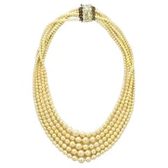 Collana a cinque fili di perle finte color crema con chiusura di strass, circa anni '50