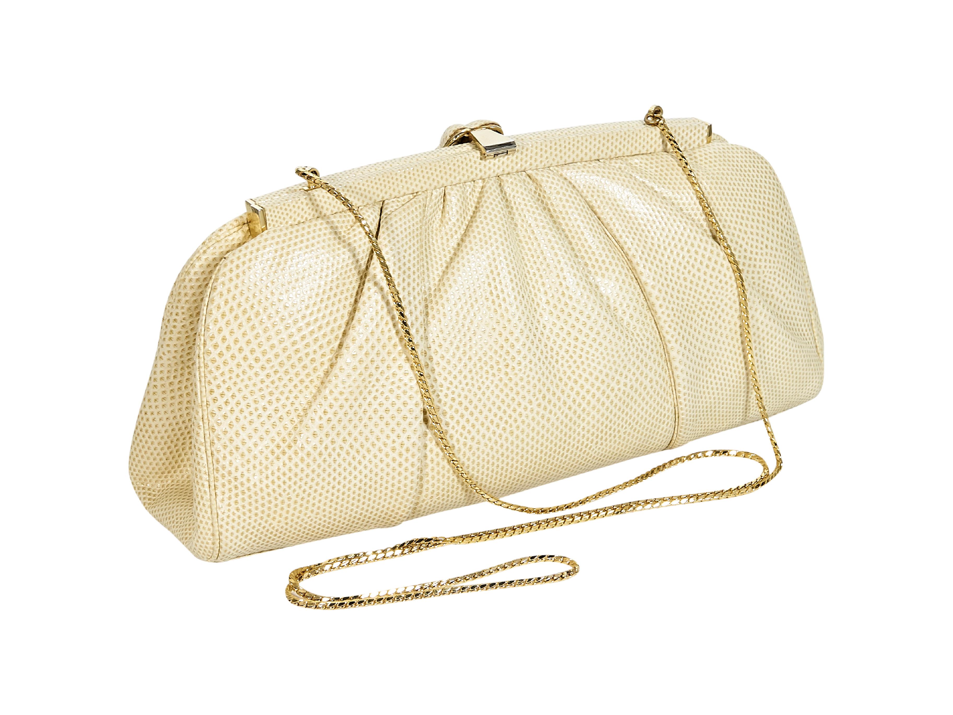 Product details:  Cream floral-clasp clutch by Judith Leiber.  Flip-top closure.  Lined interior with inner zip pocket.  Goldtone hardware.  10