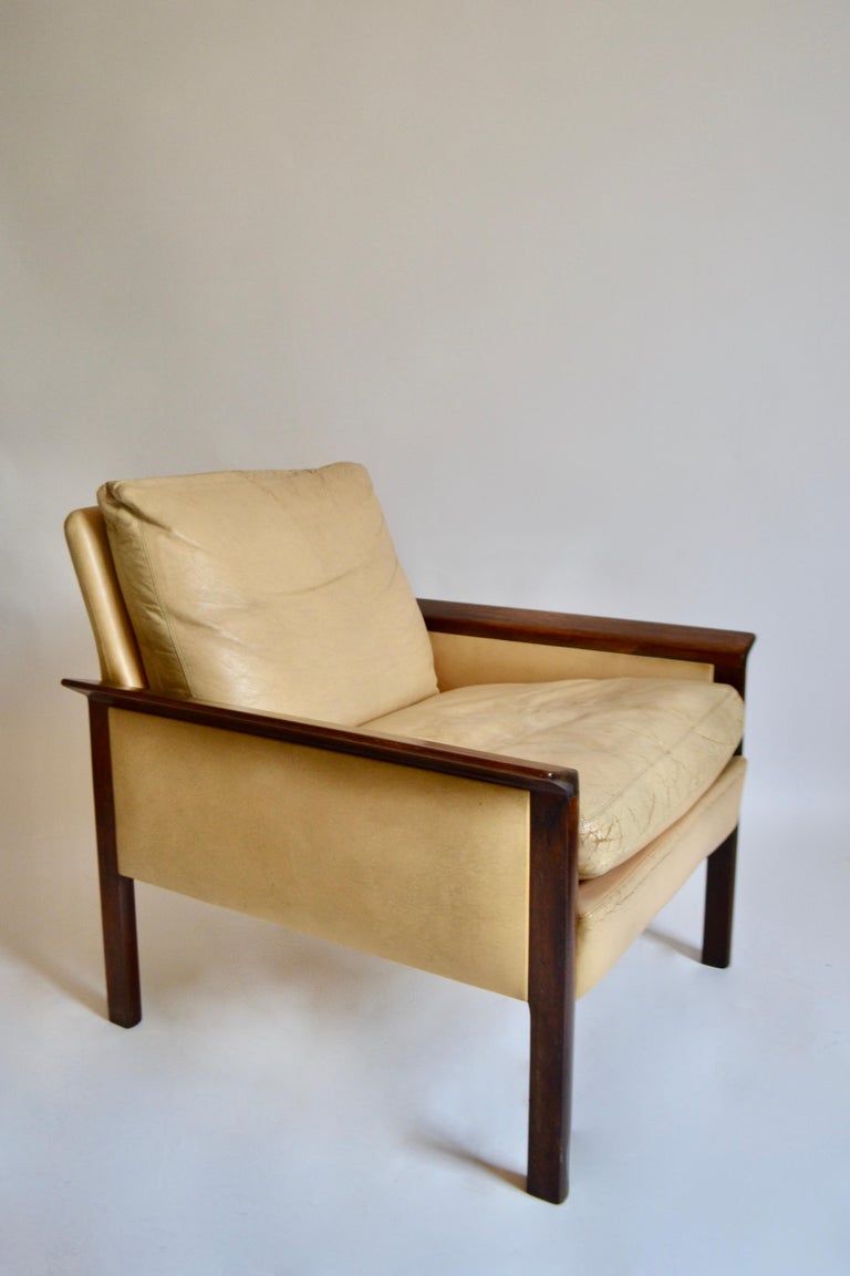Cream leather and walnut lounge chair (Model 400) designed by Hans Olsen for C S Møbler in 1966.

The chair is comprised of two cushions and retains its original cream leather upholstery with scuffs and some cracks as documented, with the walnut