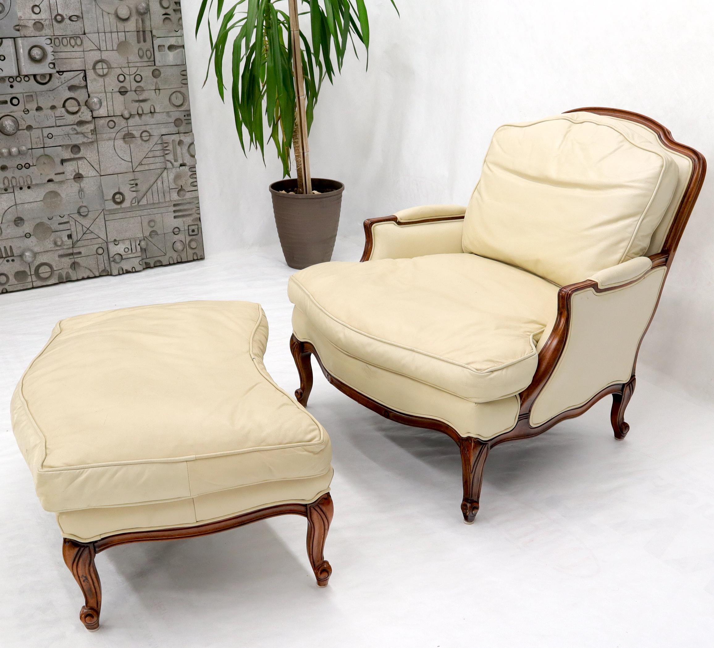 French country 2-part chaise lounge and ottoman. Hi grade supple cream leather upholstery. Beautiful carved walnut frame. Super comfortable elegant looking down filled cushions piece of furniture. Measures: Overall length 63