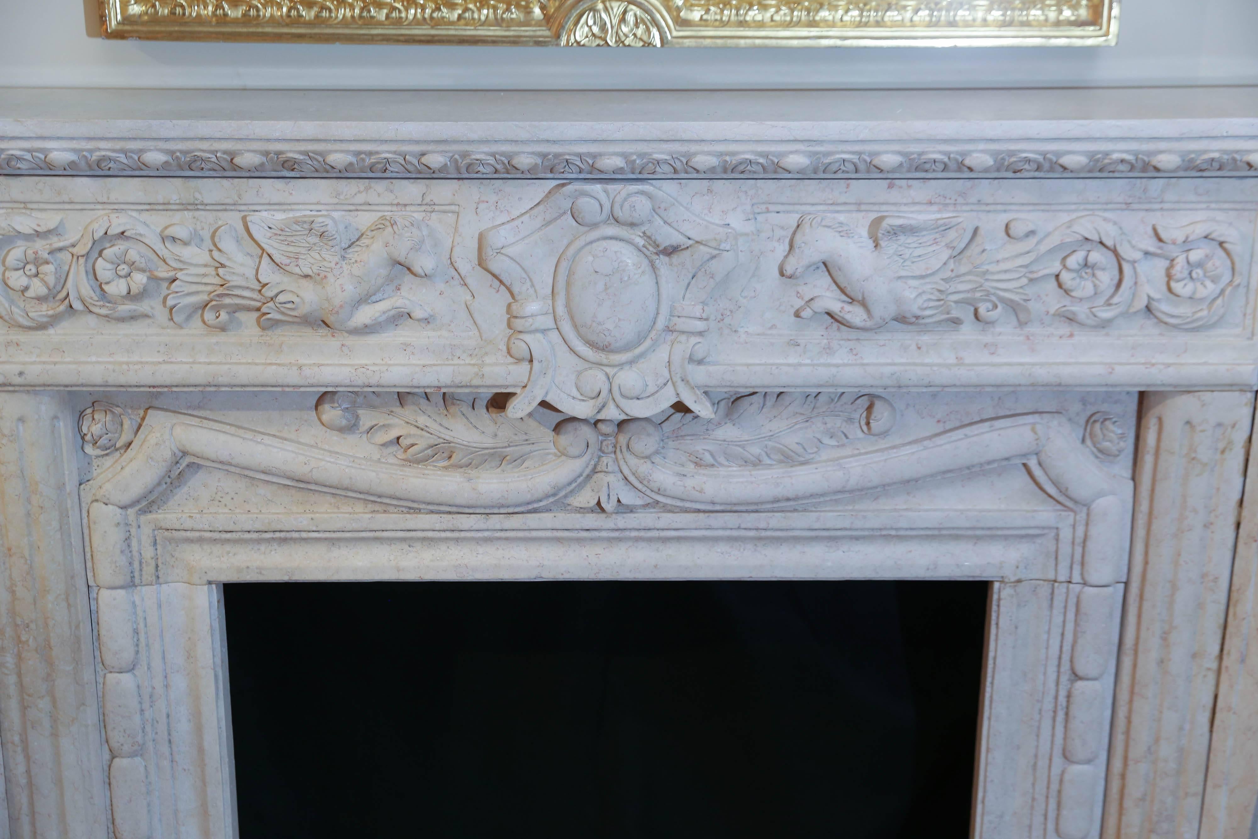 Marble mantel in cream color with carving of two flying horses
depicting Pegasus. The sides carved with shells at the shoulders.


 