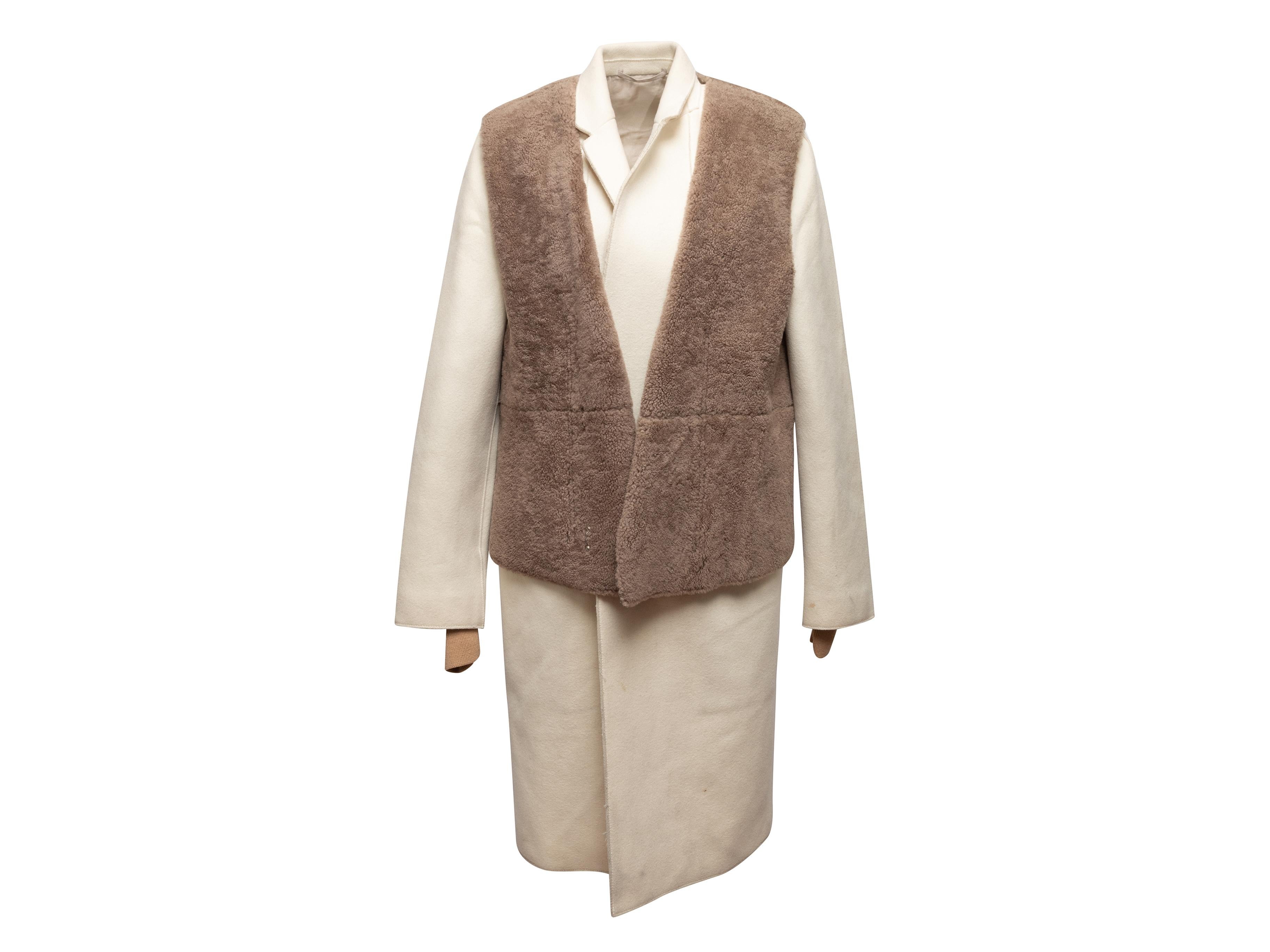 Cream long coat by Phillip Lim. Notched collar. Dual hip pockets. Detachable light brown shearling vest overlay. Concealed front closure. 40