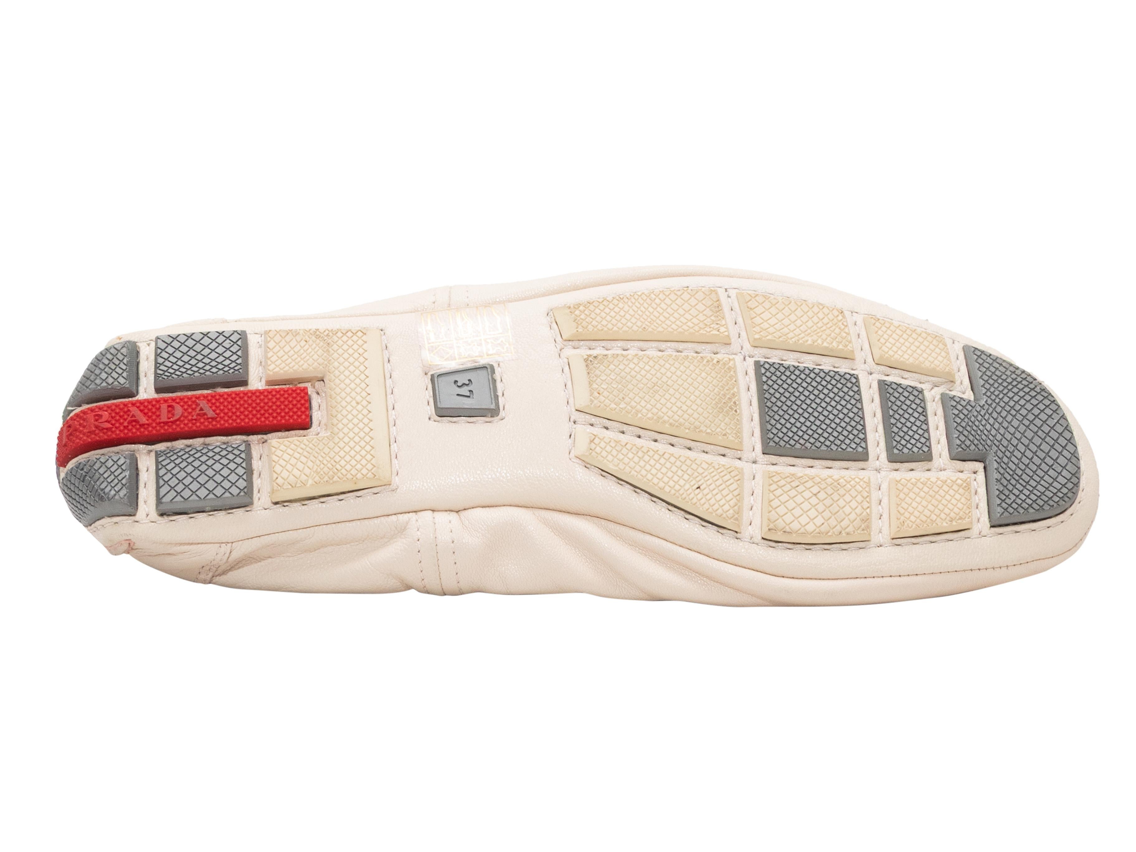 Cream leather ballet driving flats by Prada Sport. Rubber bumpers at soles and counters. 