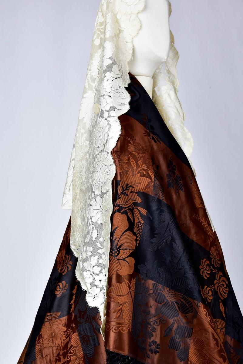 Second half of the 19th century
Spain

Mantilla or ceremonial head veil in cream silk lace called Blonde collected in Madrid. Diamond shape decorated with large flowers au naturel on a silk net background. No defect and clean. Very good condition of