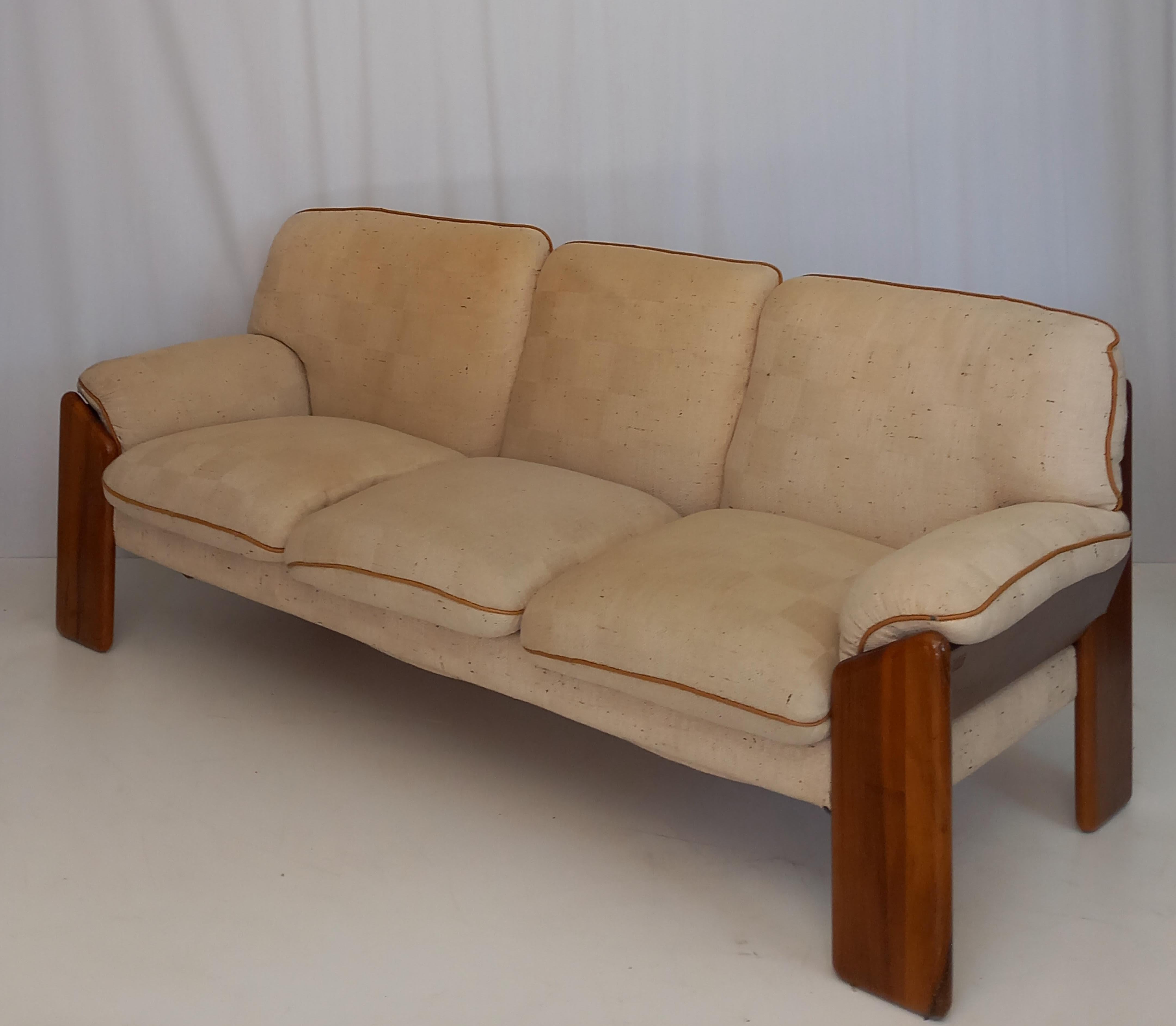 This vintage mid-century sofa, produced in the 1970s by the renowned Italian furniture firm Mobil Girgi, is a striking example of timeless design and sophisticated craftsmanship. Upholstered in cream fabric, the sofa features a sturdy walnut