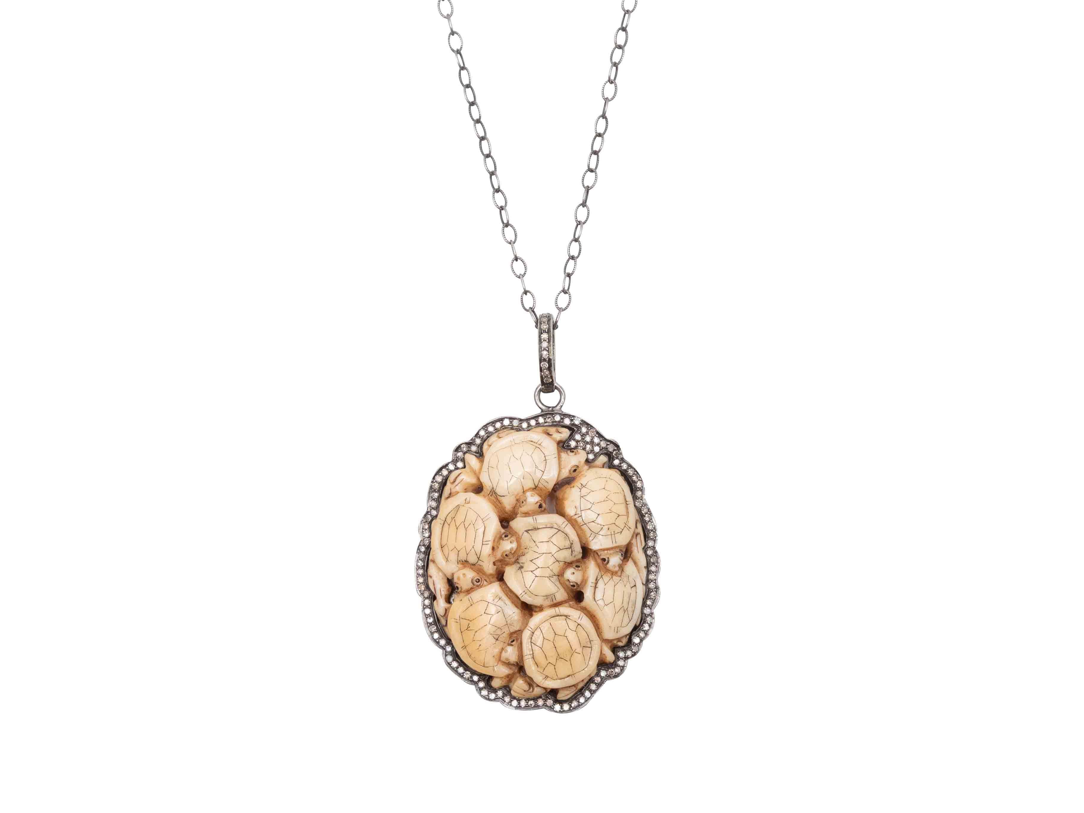 Collier avec pendentif en forme de tortue sculptée en crème et diamants pavés, par Stacey Singer. Fermeture en forme de pince de homard. Largeur de 1,75