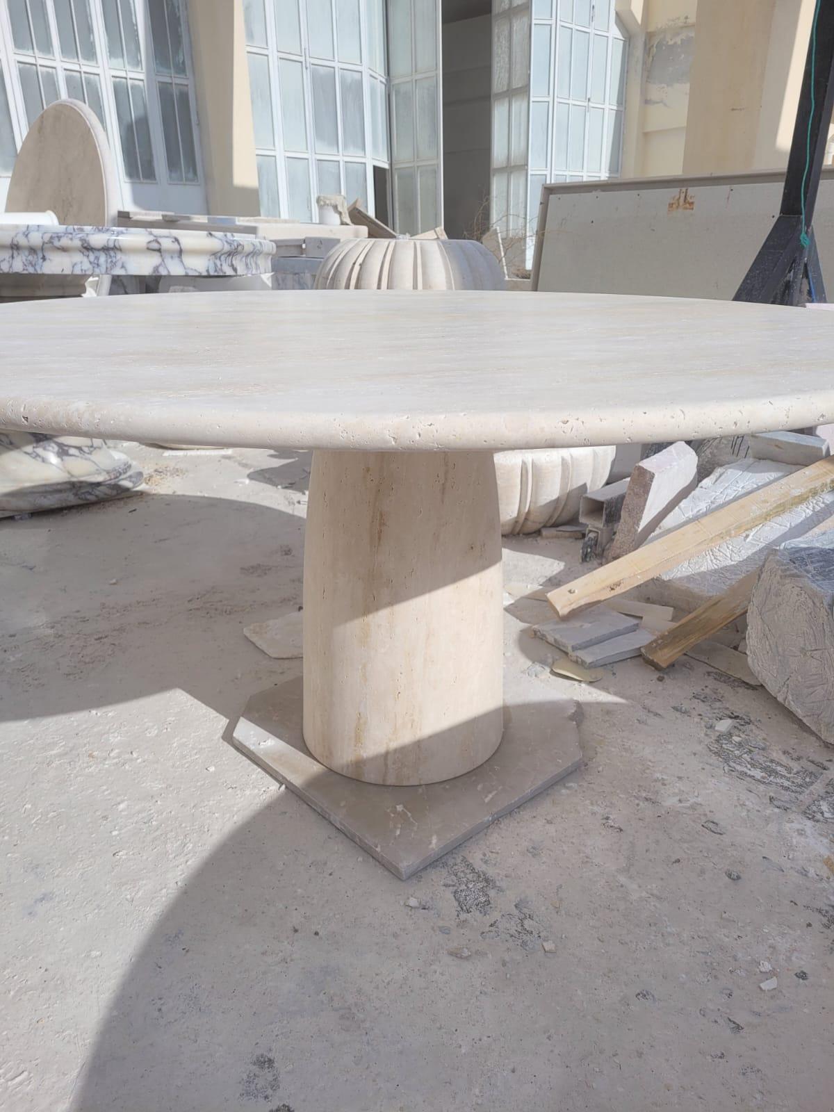 This Minimalist table is made from solid light travertine, featuring a colon, cone shaped foot and a thick circular travertine tabletop that balances perfectly and securely with its own weight. 

Drawing inspiration from the vintage pieces of Angelo