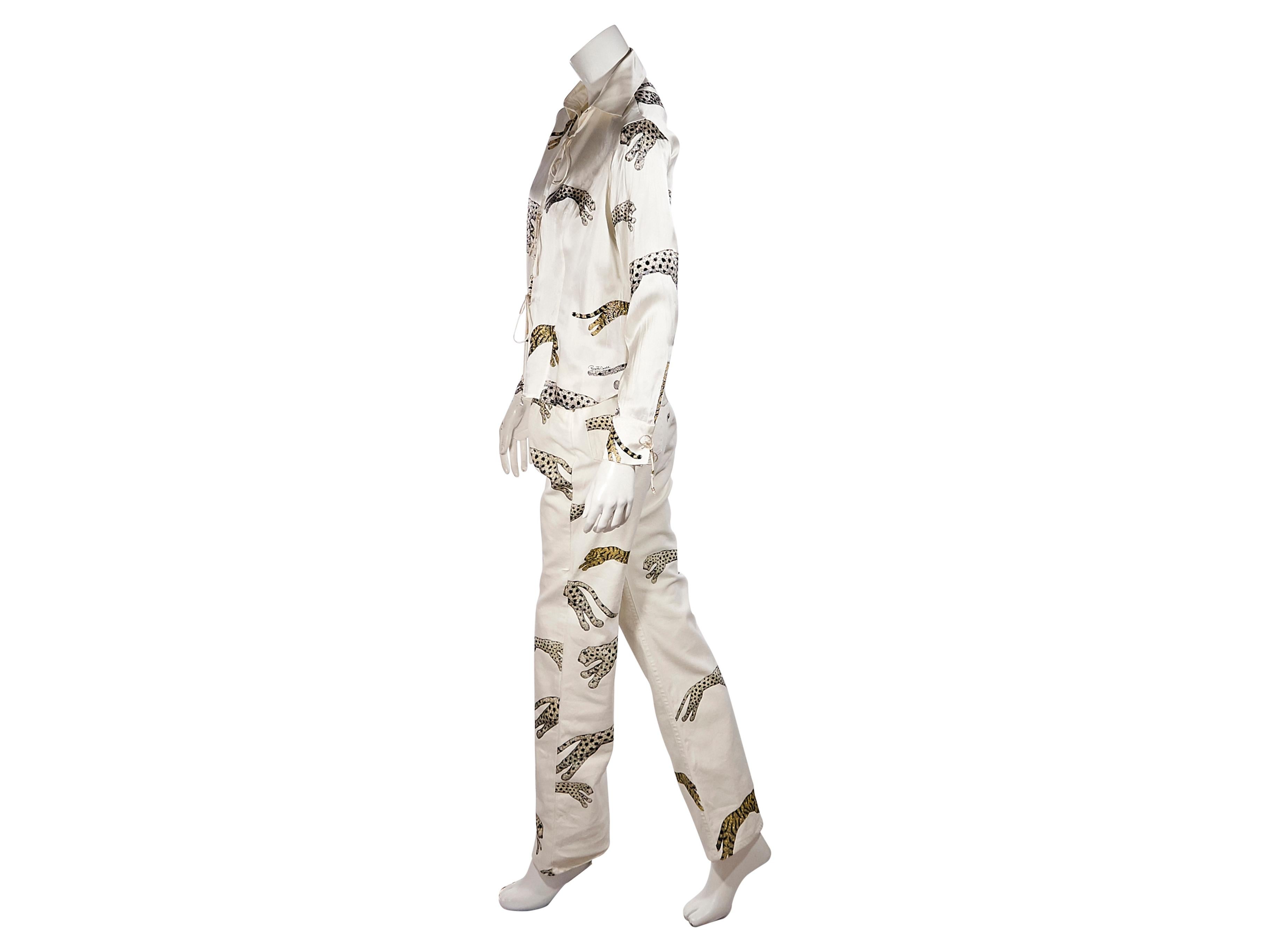 Product details:  Vintage cream embellished tiger silk blouse and jeans set by Roberto Cavalli.  Circa the 1990s.  Spread collar.  Long sleeves.  Tie-front closures.  Matching jeans.  Banded waist with belt loops.  Button and zip fly closure. 