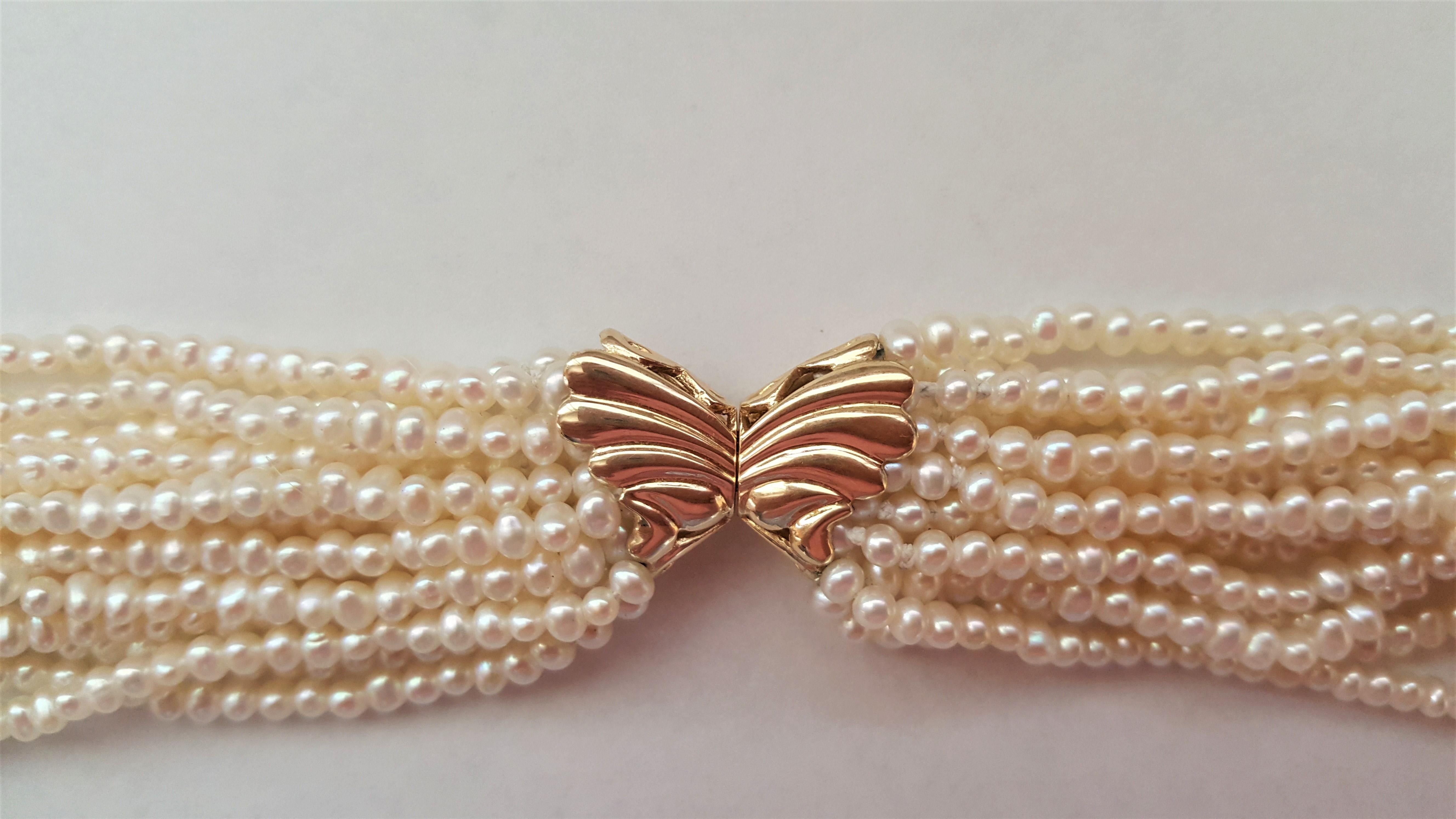 A beautiful 20-inch length multi-strand cream white grade AA pearls that range in size from 2.5-3+ in size. There are 15 strands of pearls that are secured with a 14kt yellow gold butterfly clasp. The clasp is stamped 585 and is 23mm x 11mm in size.