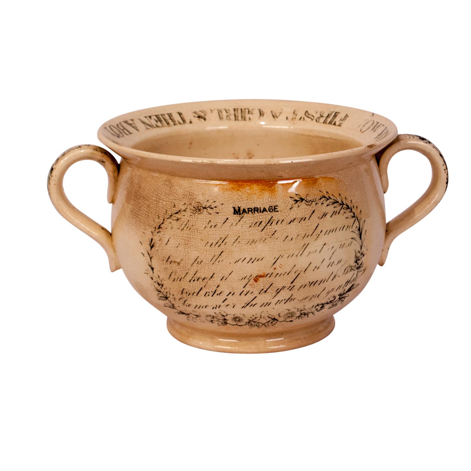 An early 19th century English Creamware chamber pot with an ogre on the bottom and a frog on the side. Made as a wedding present.