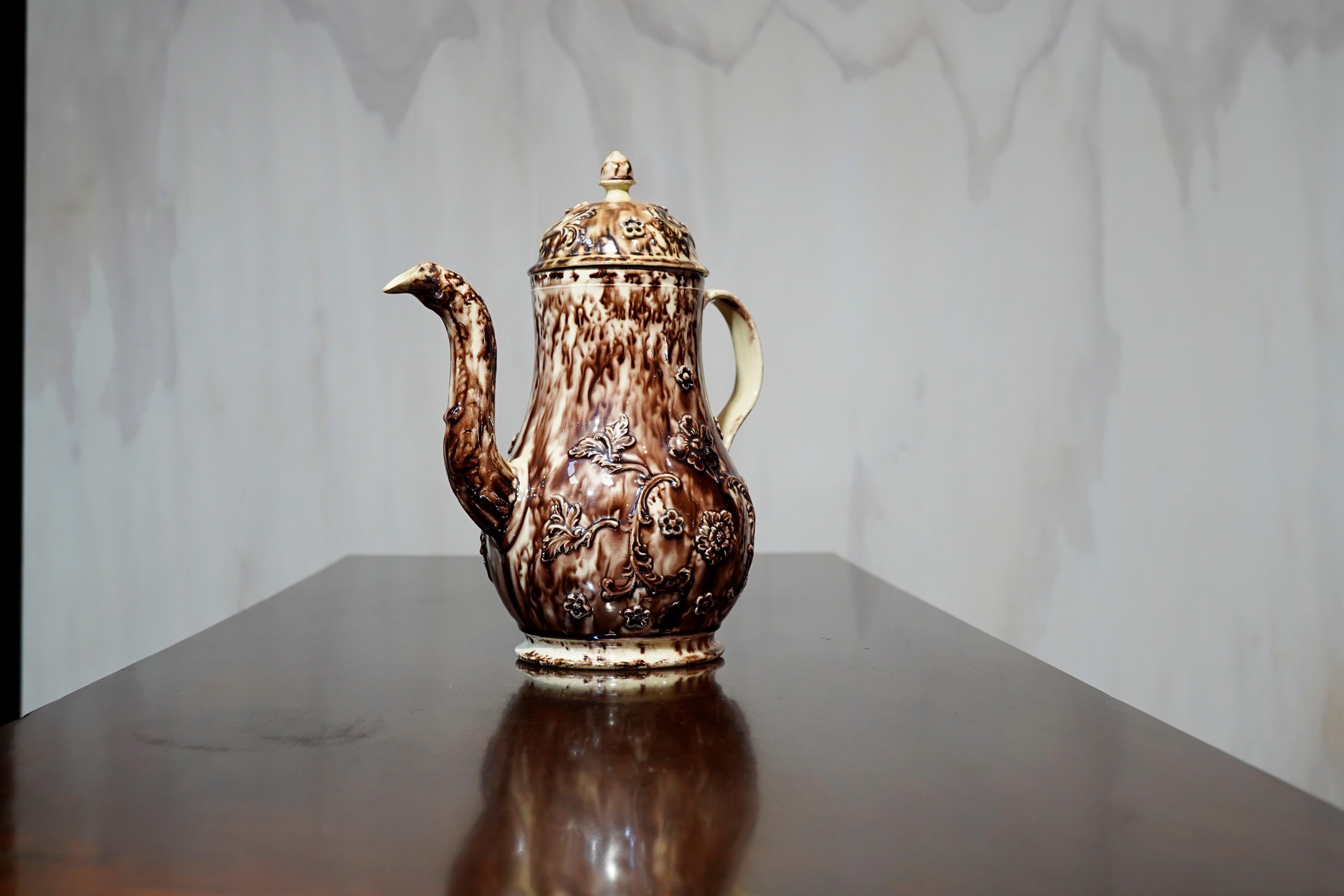 Creamware coffee pot, of tall baluster form, glazed in a superb Whieldon tortoiseshell-type glaze, applied with trailing rose sprigging.

ex- Zorensky Collection, circa 1765.