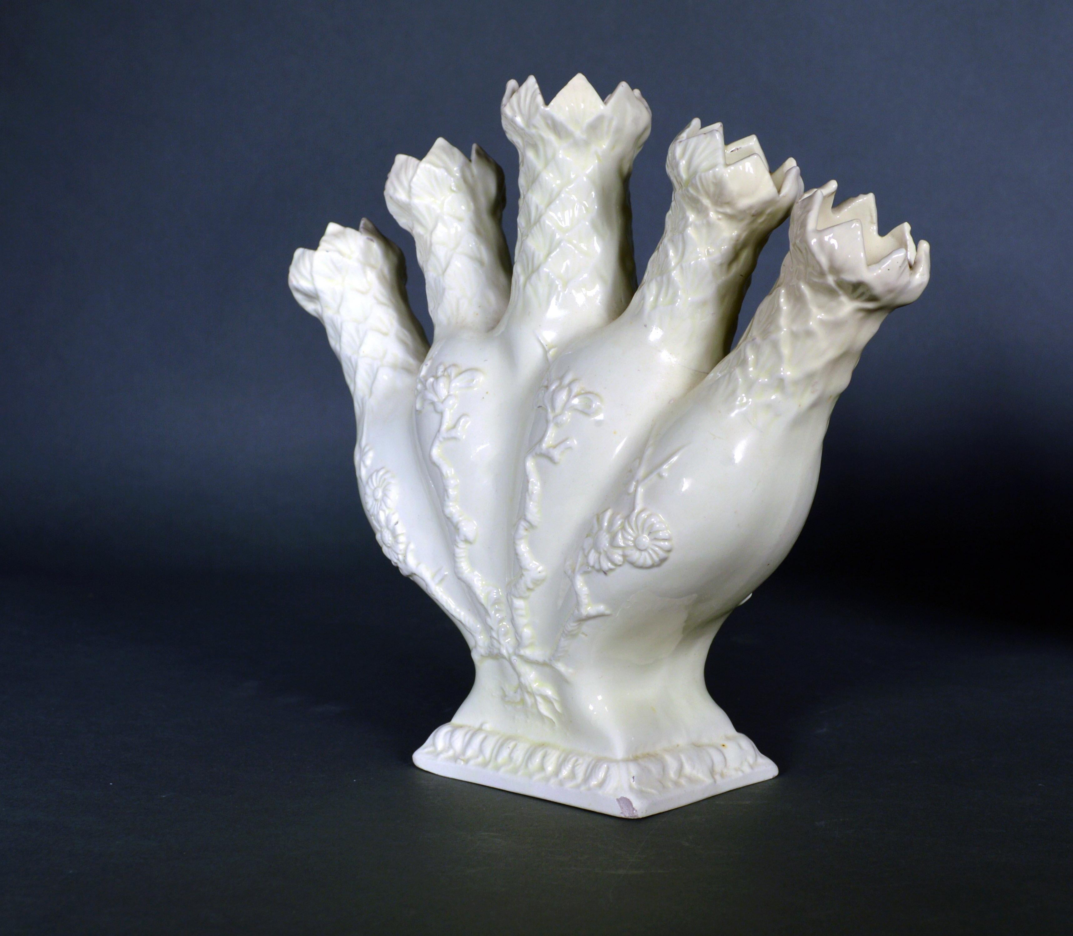 Creamware finger or quintal Vase,
19th century,

The English pottery creamware finger or quintal vases The five-fingered flower vase has a molded design of branches and flowers issuing from roots starting close to the base and the top of each