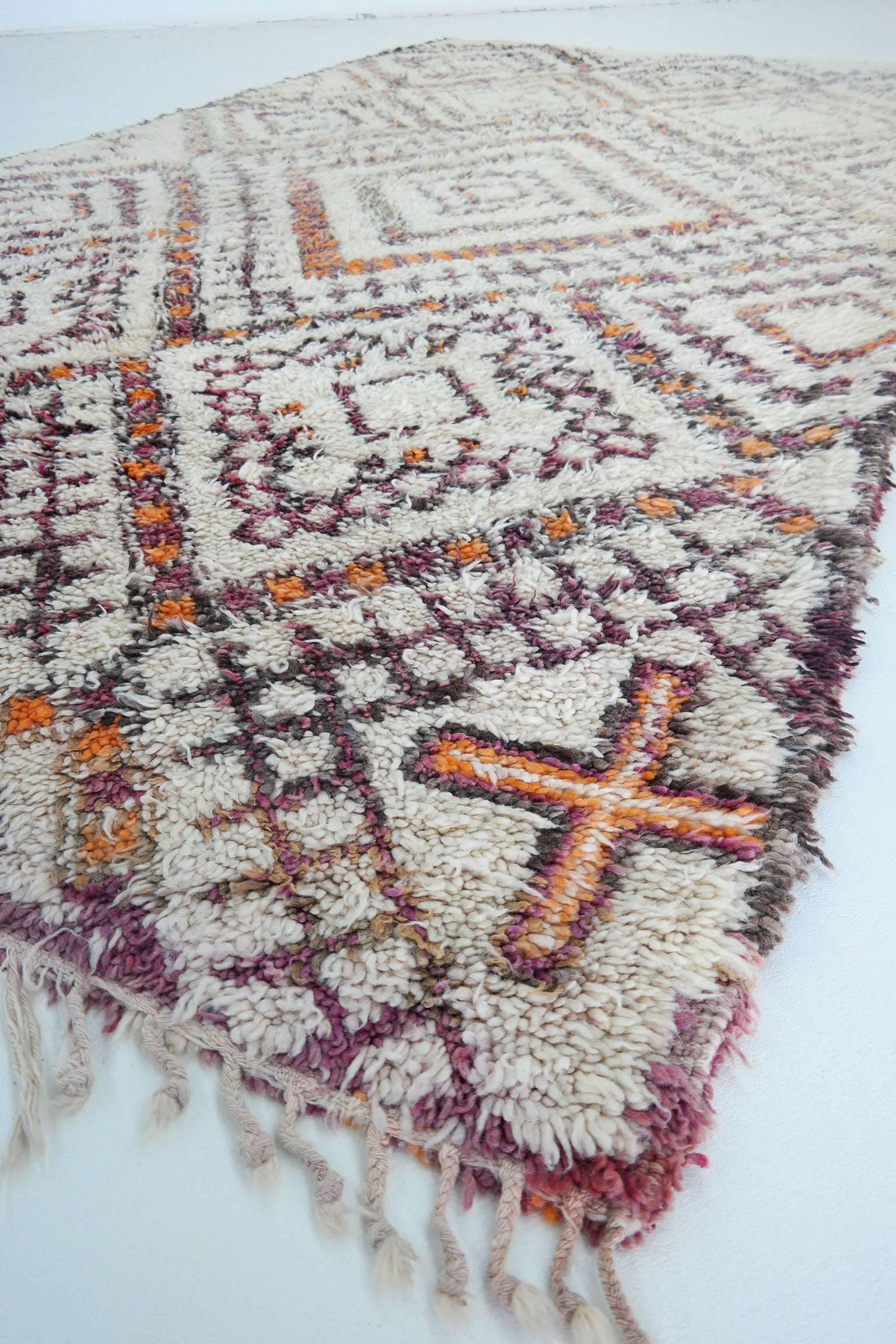 Beni Ourain Rug

As stunning vintage Moroccan rug in great condition. This beauty has a pattern with beautiful color accent and a beautiful butter cream base. The shades of orange and aubergine purple are naturel dye. 
Beni Ourain rugs have a story