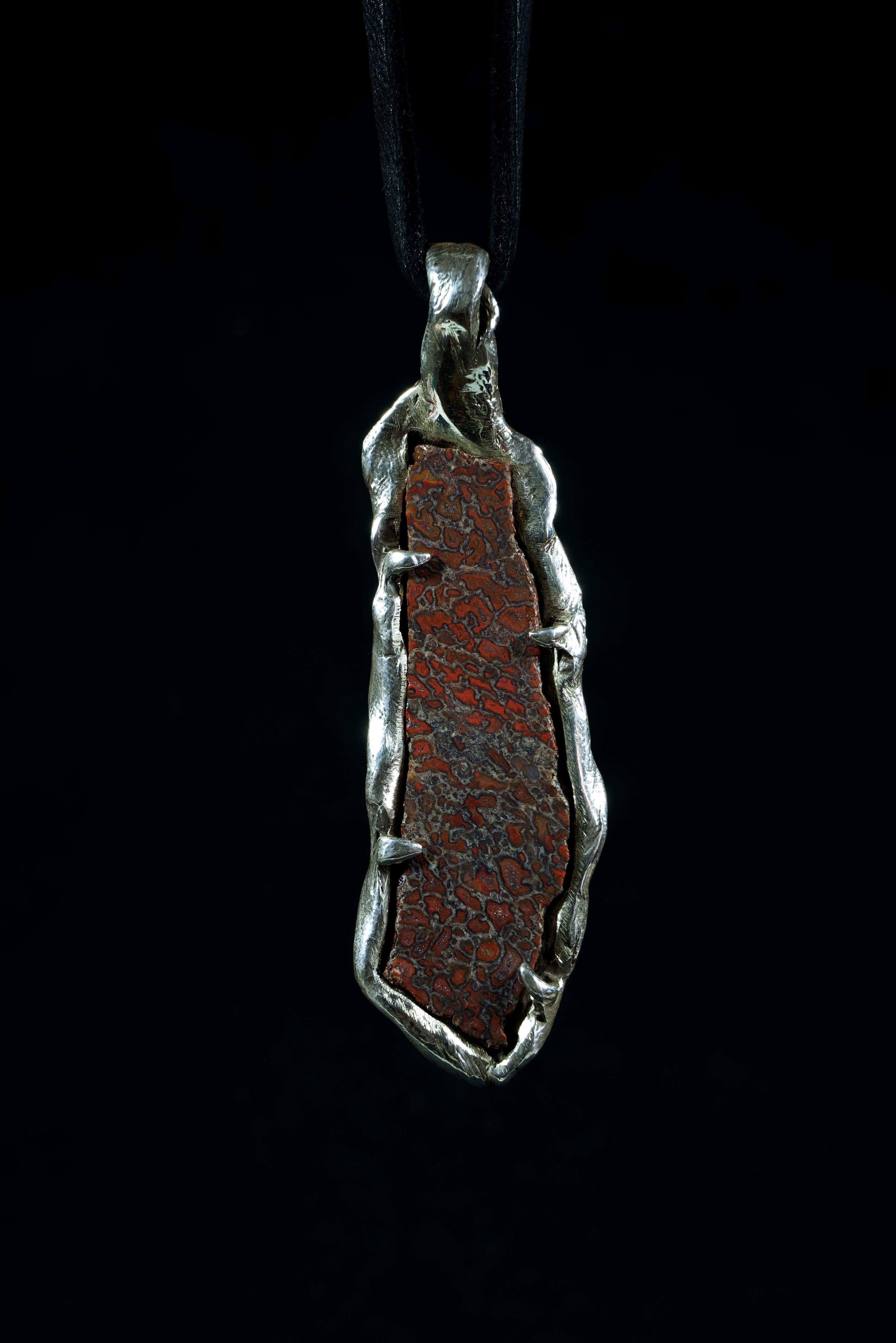 The agatized dinosaur bone used in this pendant is a unique and rare piece of history and has beautiful and intricate patterns that have been formed over millions of years through fossilization. The detailed design of the pendant is inspired by the