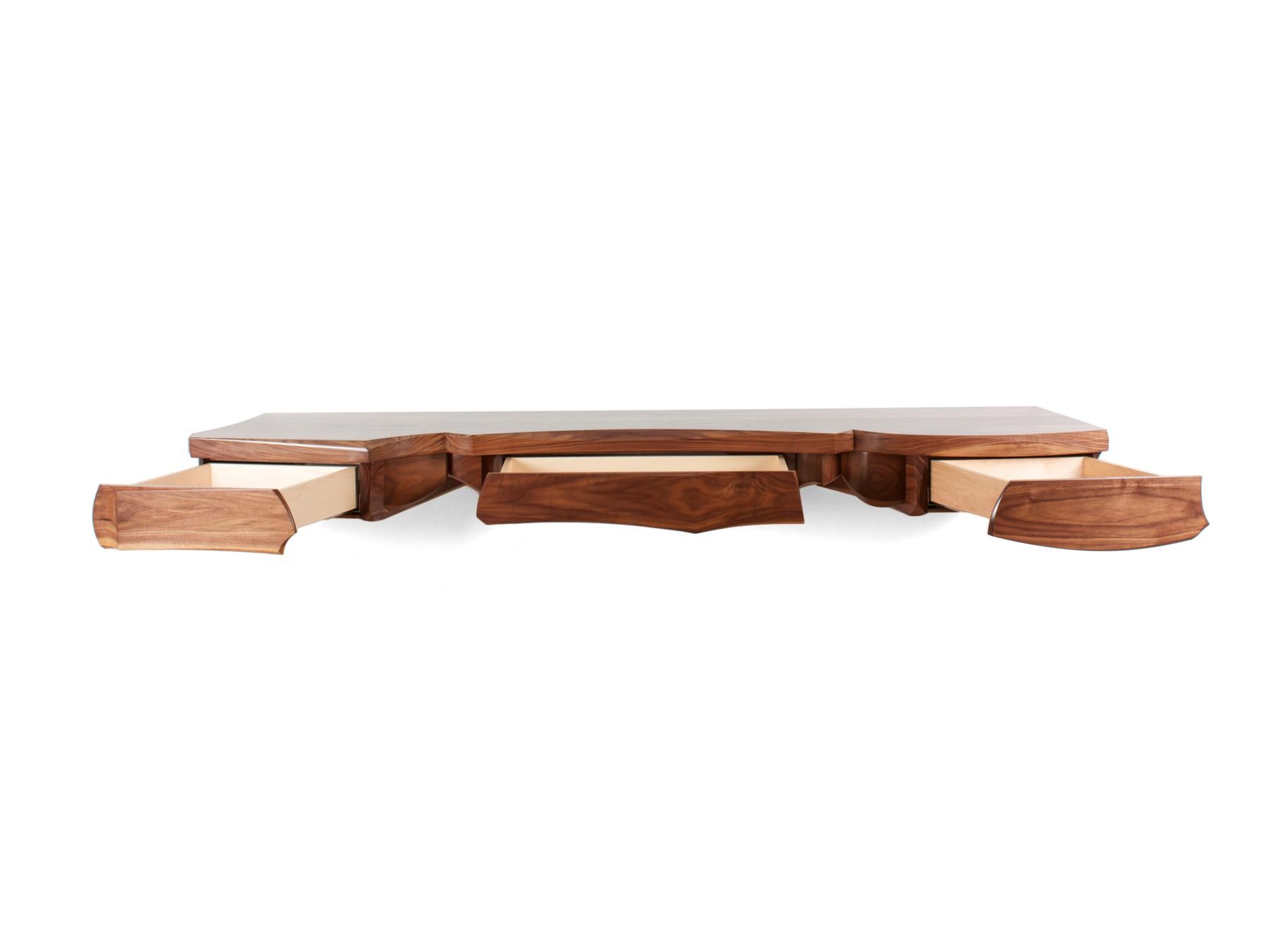 This version of the floating console explored a slightly more symmetrical shape than some of the other iterations of this piece. The focus was on the three drawers that are incorporated within the sculptural under structure of the piece. The narrow