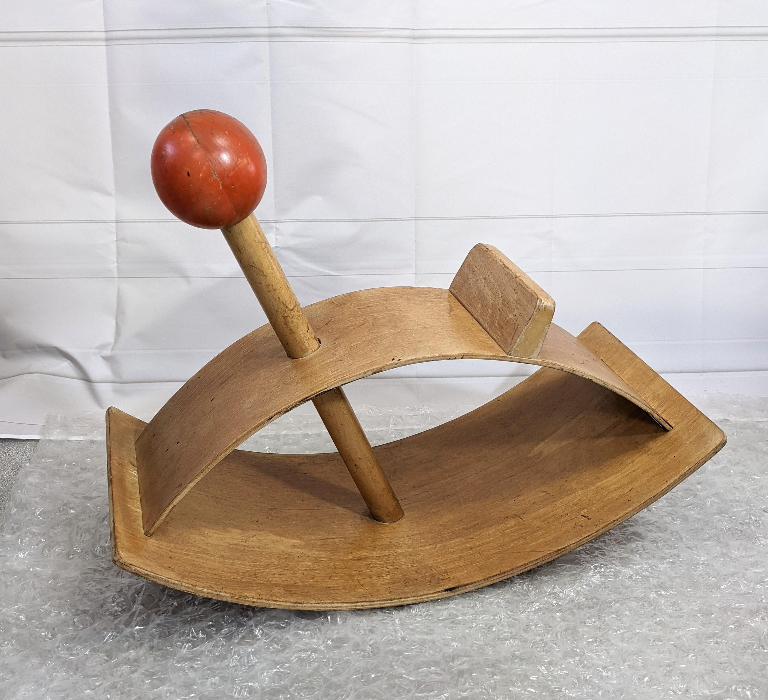 Creative Playthings, dondolo in legno curvato di metà secolo per bambini disegnato da Gloria Caranica, circa 1964. Un design iconico nella collezione del Museo d'Arte Moderna. 
Compensato di betulla caldo. Progettato nel 1964 negli Stati Uniti.

