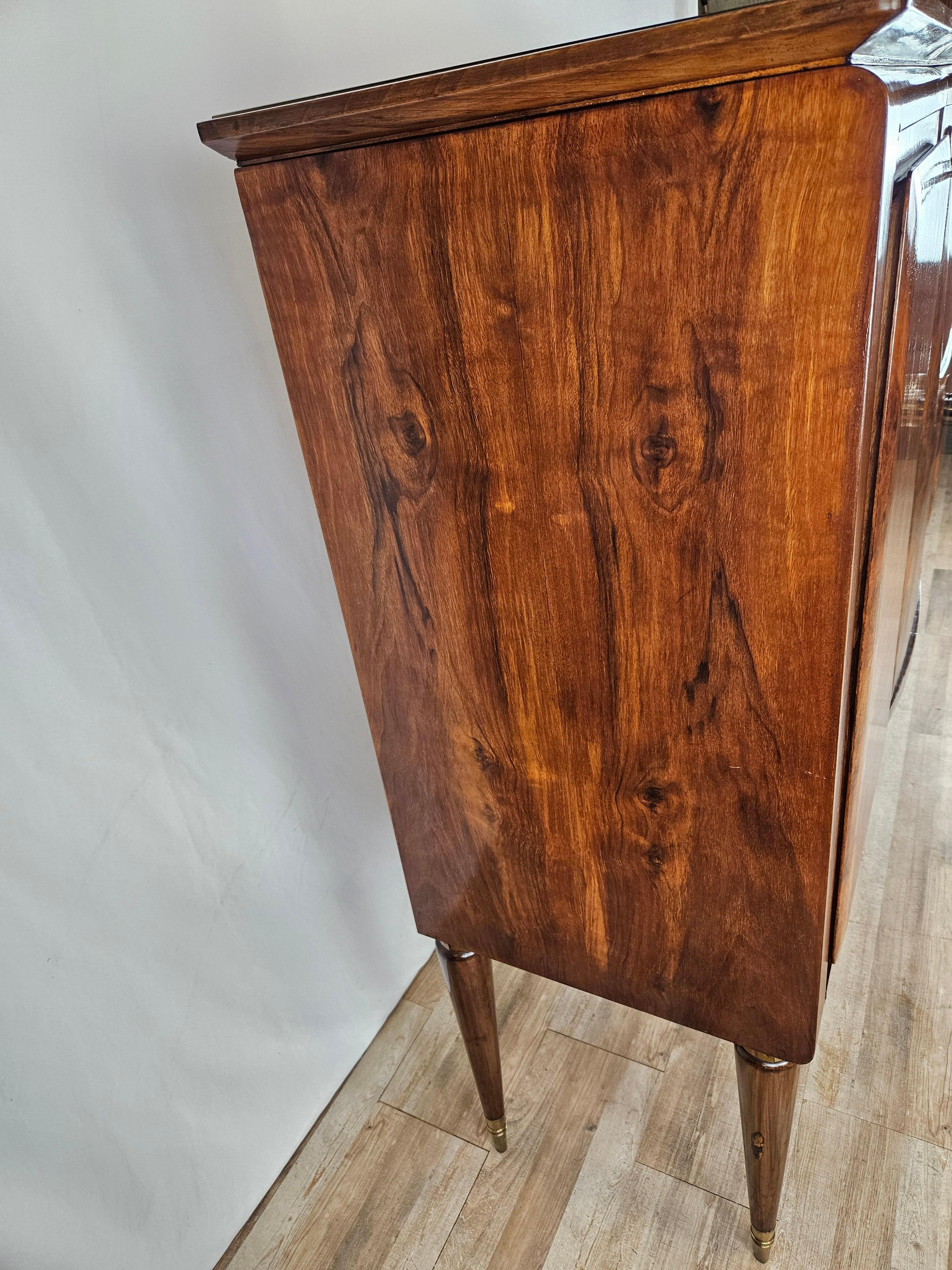Elegantes Sideboard italienischer Herkunft aus der Mitte des 20. Jahrhunderts, hochwertig verarbeitet in Nussbaum mit Ahornleisten an Türen und Innenschubladen.

Der Schrank hat eine gewölbte Glasplatte an der Vorderseite, drei große Türen mit einem