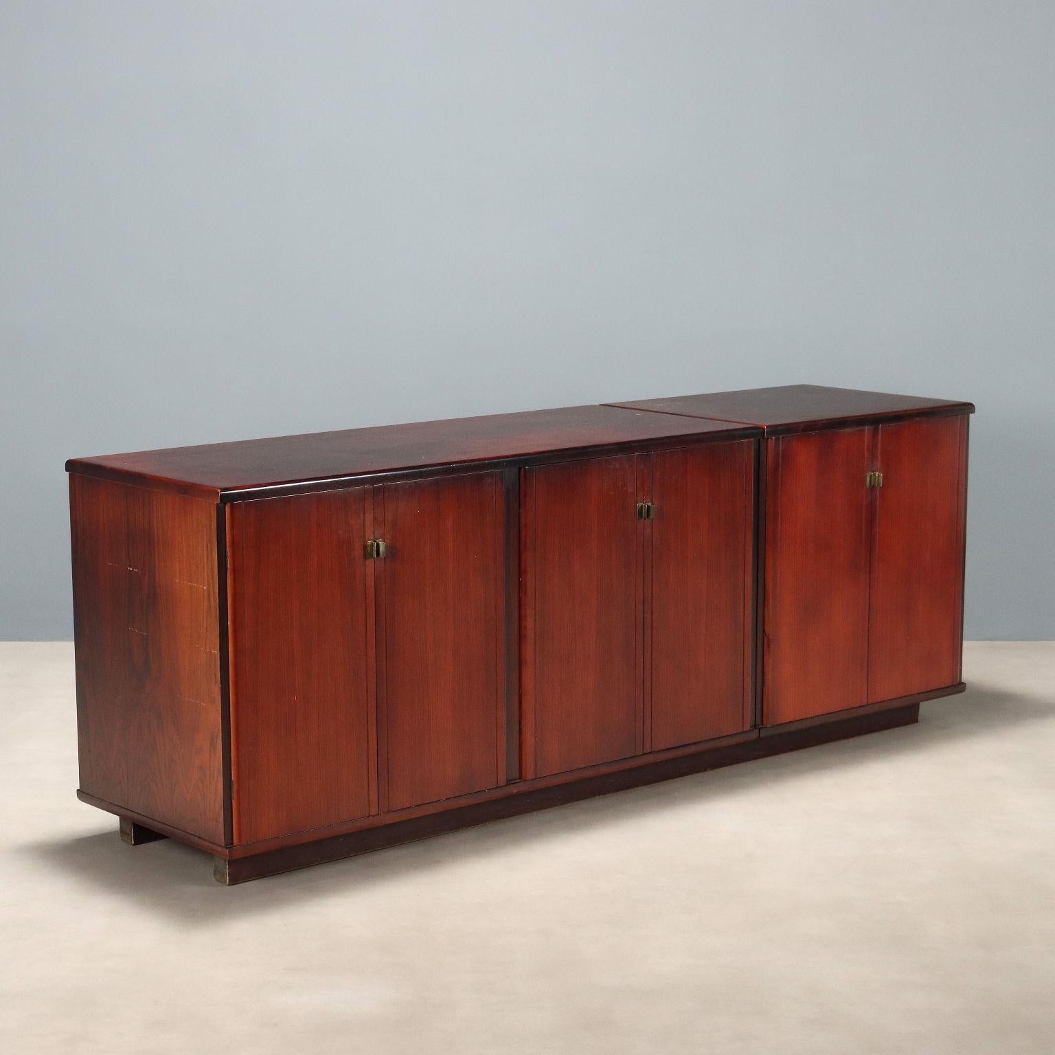 Credenza vintage con ante a battente e maniglie in ottone, in legno con impiallacciatura in legno esotico. In buone condizioni generali con qualche segno del tempo come visibile in foto.
