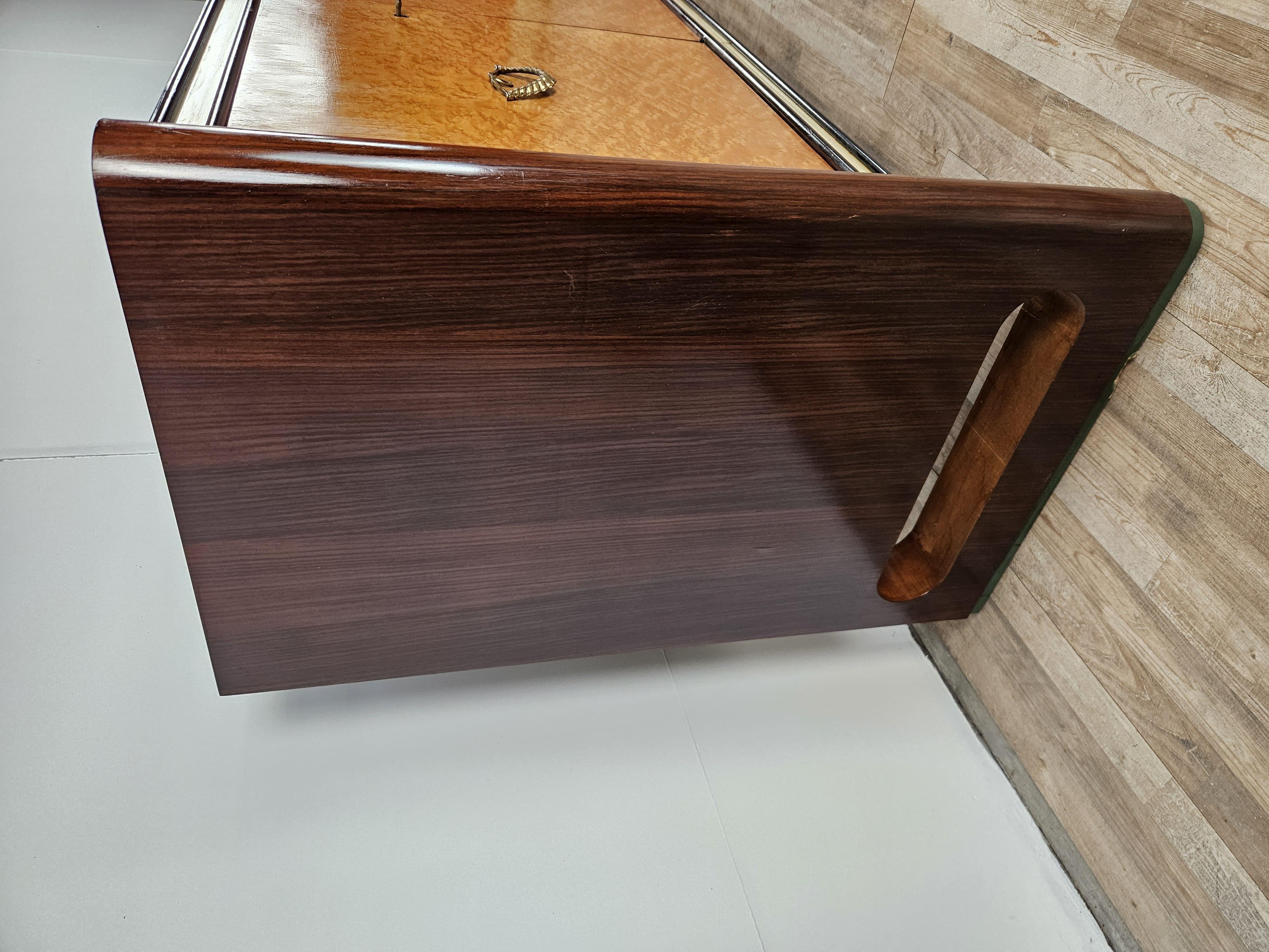 1950s sideboard designed for Permanente Mobili Cantù and attributed to designer Osvaldo Borsani.

The cabinet is presented in maple and rosewood with a black glass top shelf and four doors with ample interior space and shelves.

With an understated