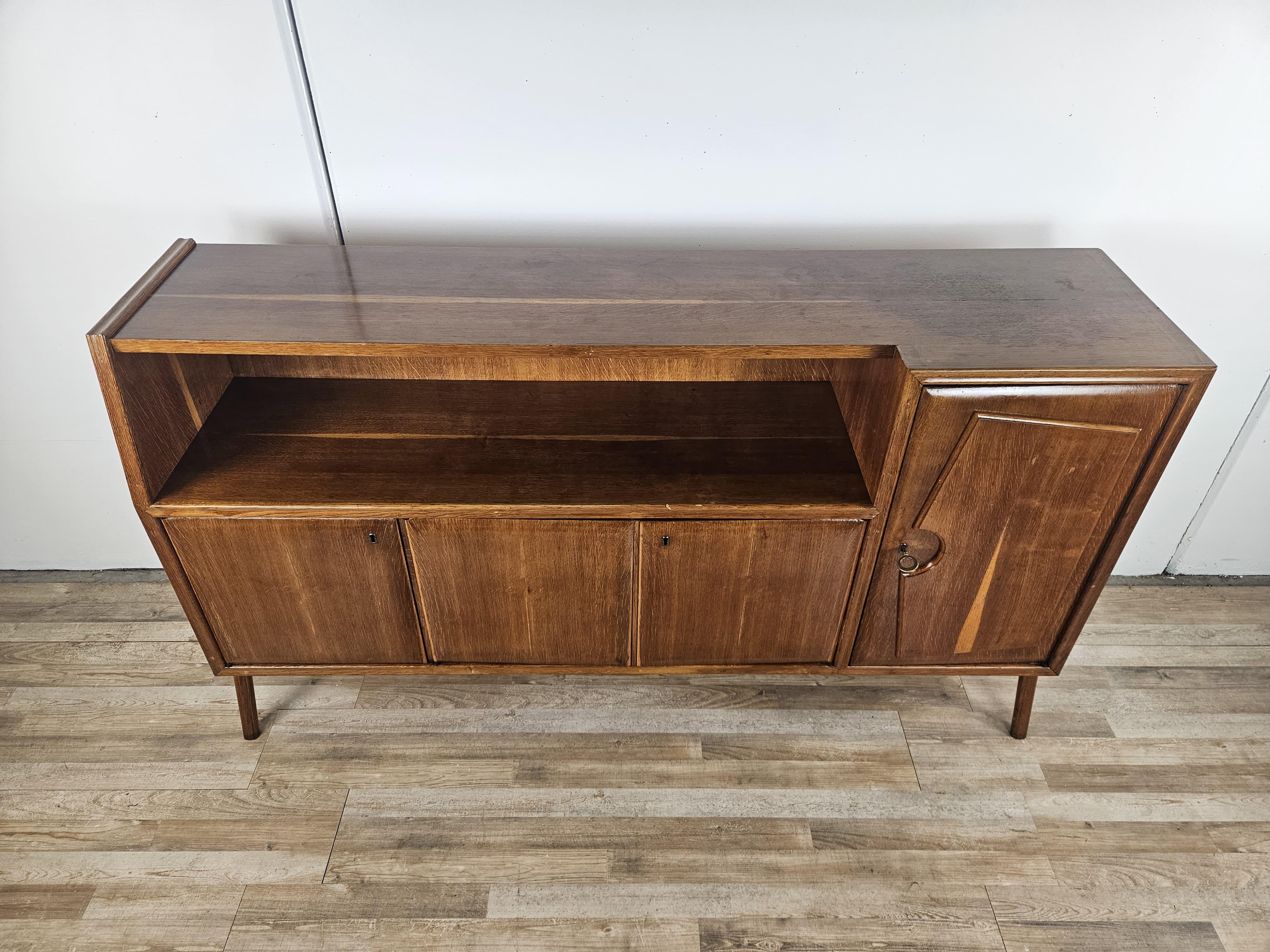 Peculiar Art Deco-style sideboard from the early 1950s, made entirely of walnut-stained beech with large open-plan compartment and interior shelves at the finished doors.

The cabinet lends itself to any use, from a sideboard in the kitchen to a