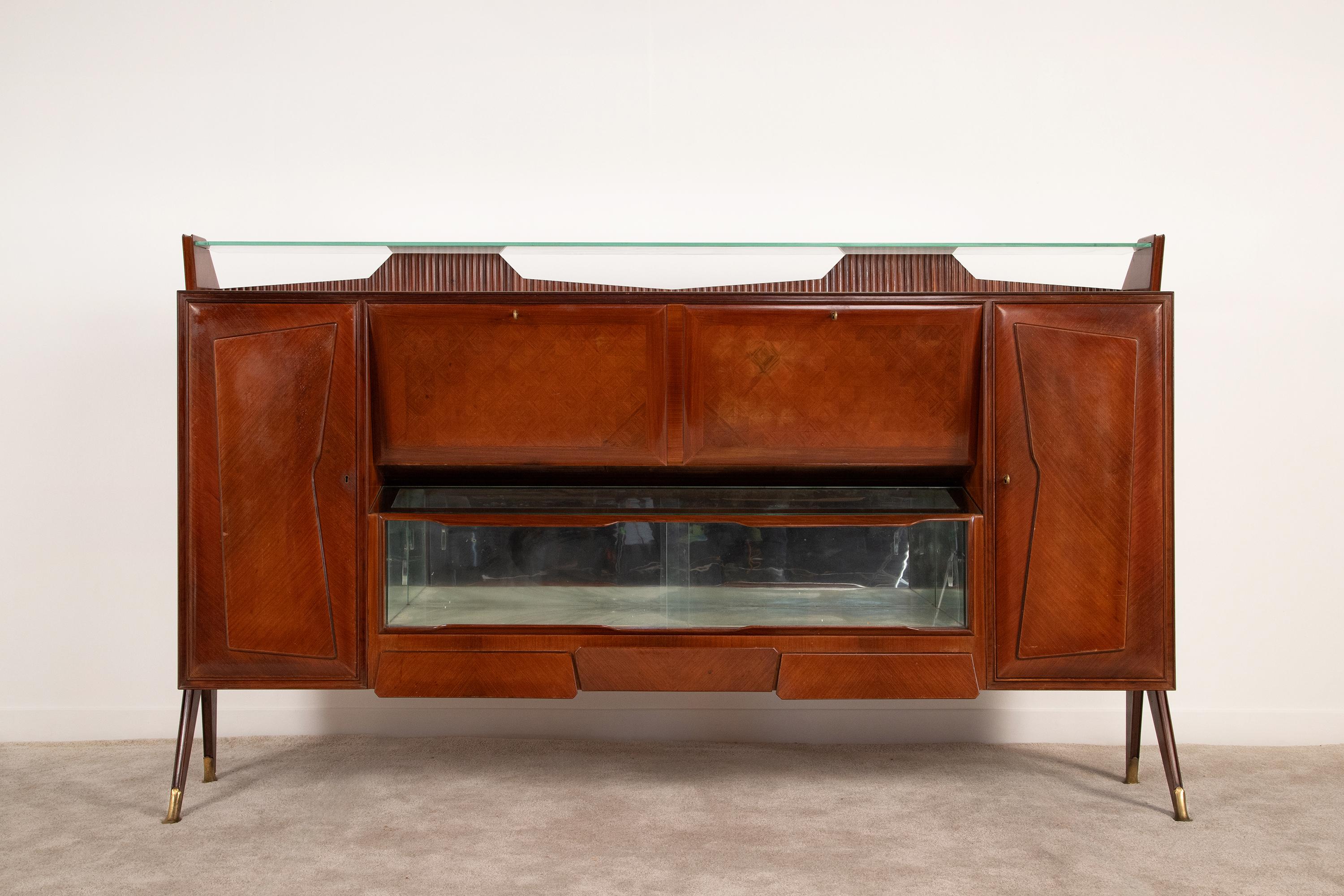 Gorgeous 1950s highboard bar attributable to Vittorio Dassi. The complexity of the line and the geometry of the shapes give elegance and at the same time solidity to the whole structure.
A classic example of Italian craftsmanship enriched with