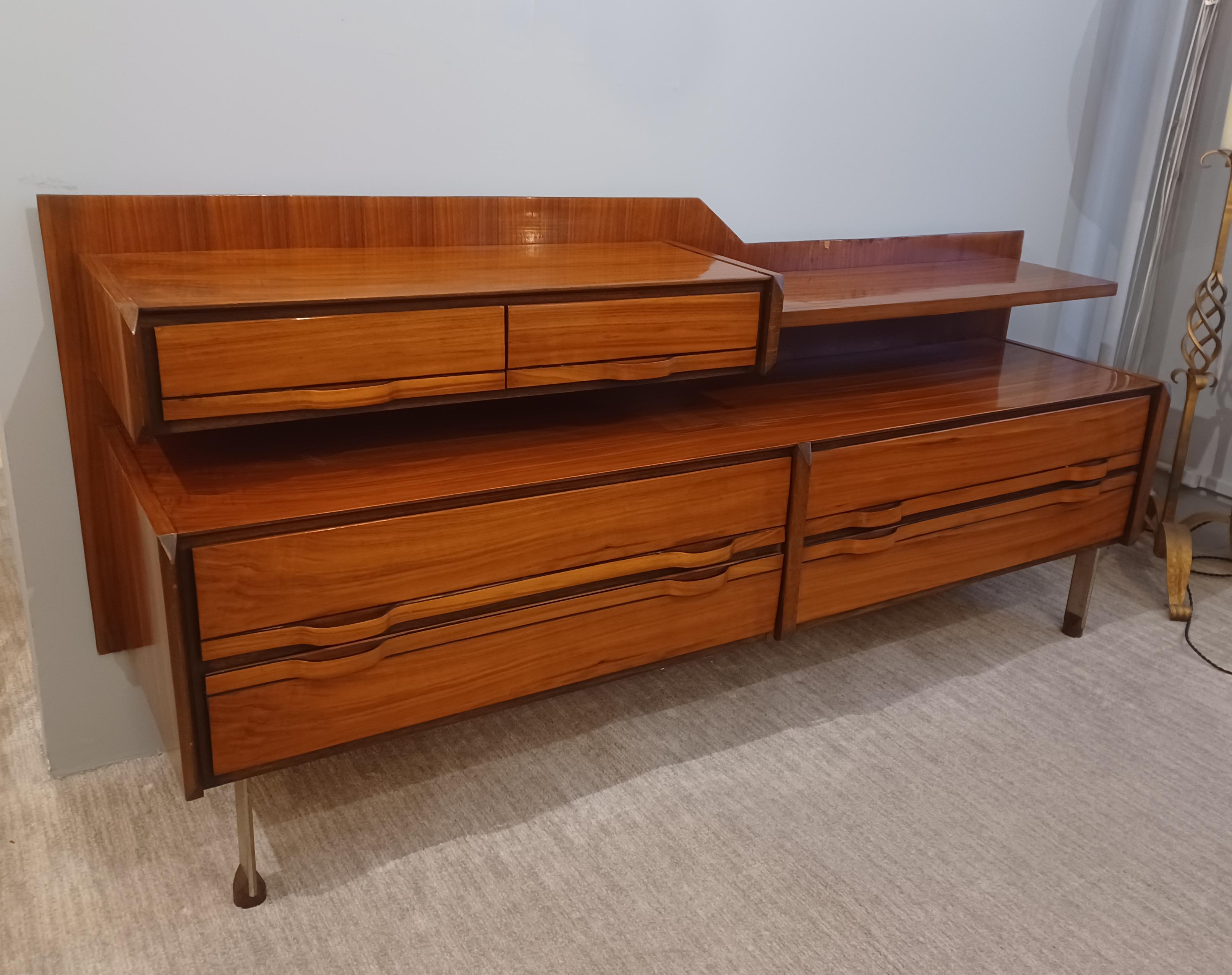 Aparador modernista de Gianfranco Frattini para La Permanente Mobili Cantù.
Madera de teca con seis cajones elevados sobre patas de acero con pies de madera.
El armario tiene un nivel superior con dos cajones pequeños y un estante. 
El nivel