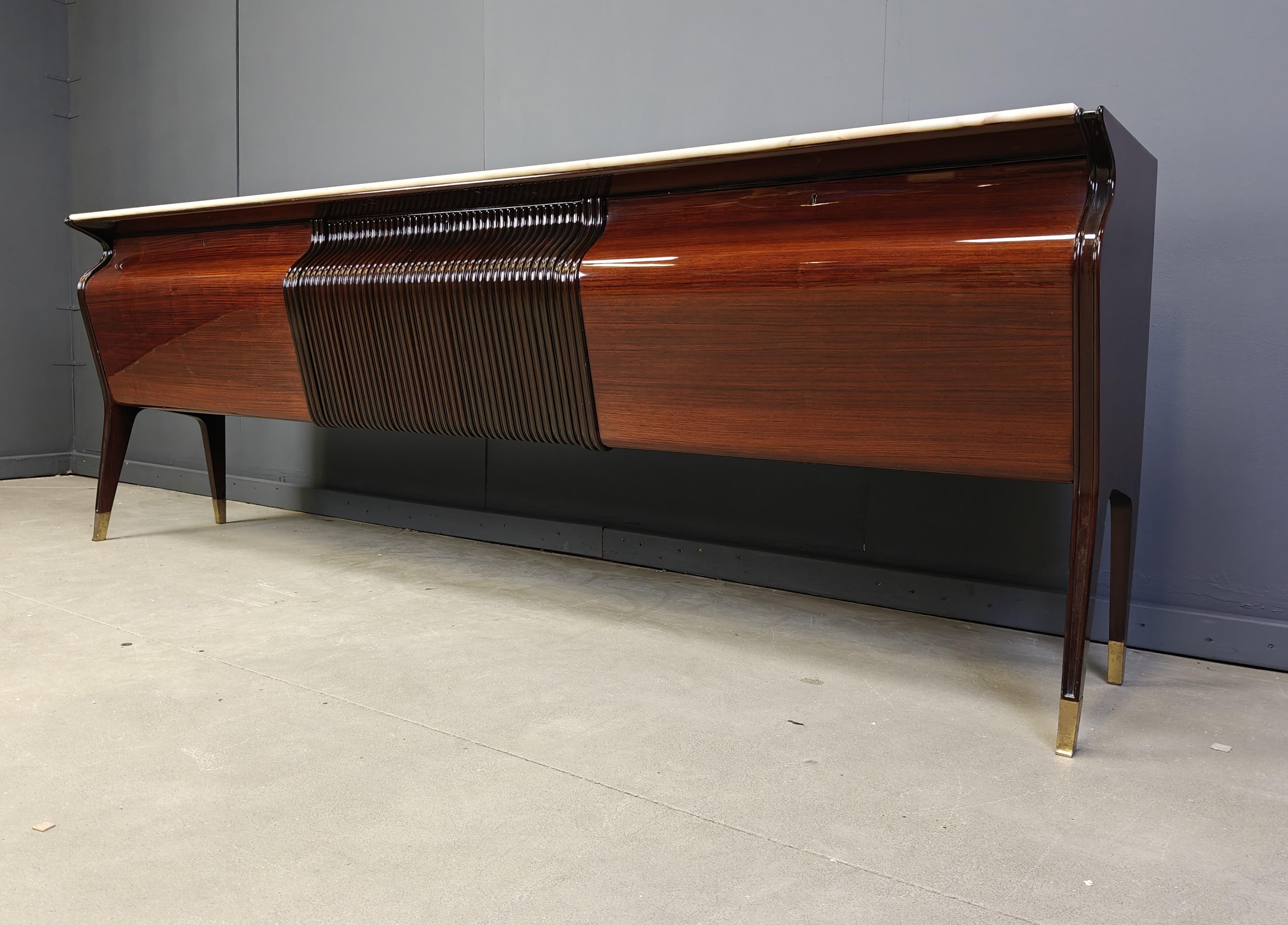 Squisita credenza o credenza disegnata da Osvaldo Borsani per Atelier Borsani Varedo.

Questa elegantissima credenza italiana di metà secolo è realizzata in legno di mogano di alta qualità, con un piano in marmo bianco e punte in ottone sulle