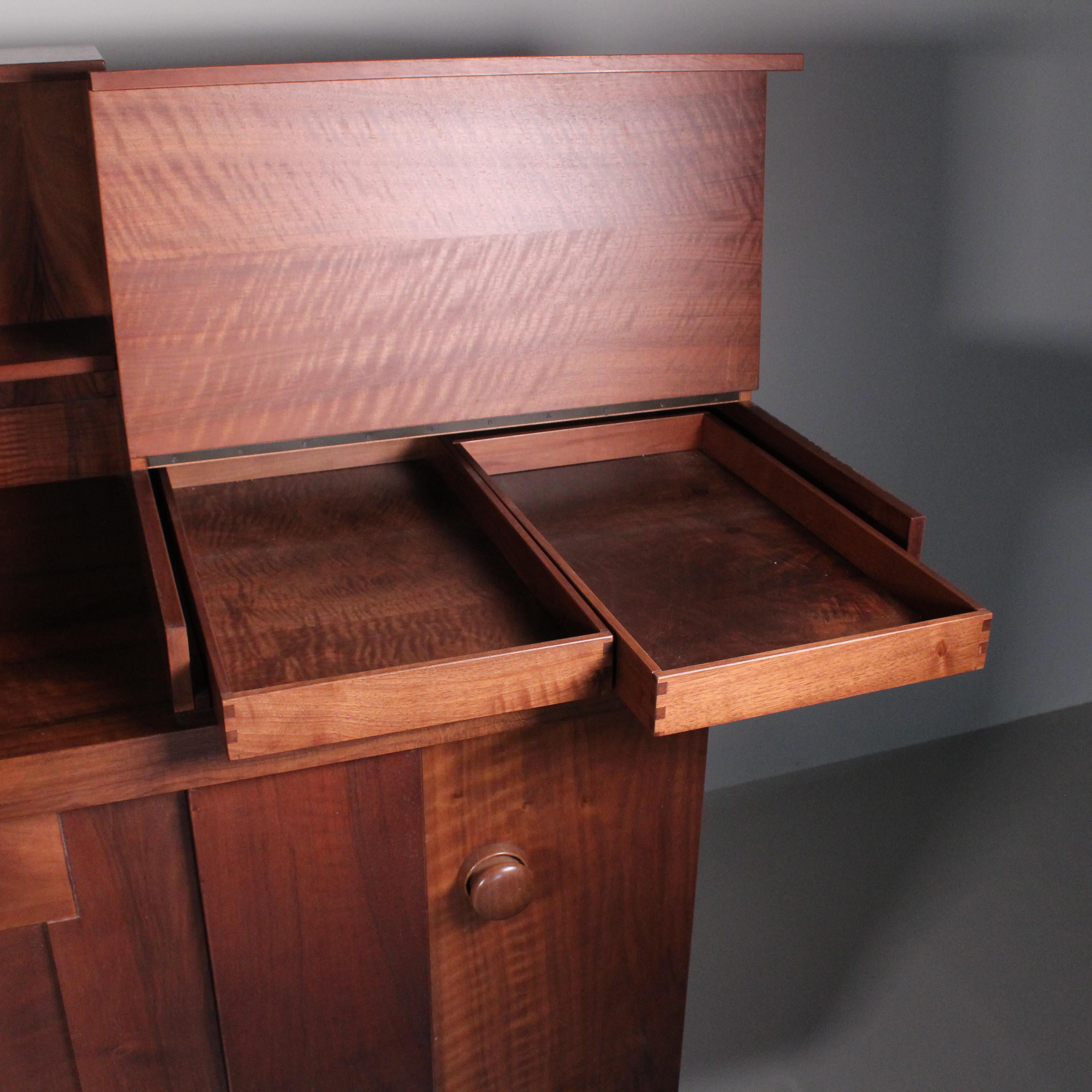 Wonderful sideboard designed by Silvio Coppola for Bernini in 1968. The frame is made of walnut wood and features eight compartments of the same size, a compartment for porcelain vases, two covered trays with flaps, two central doors, two corner