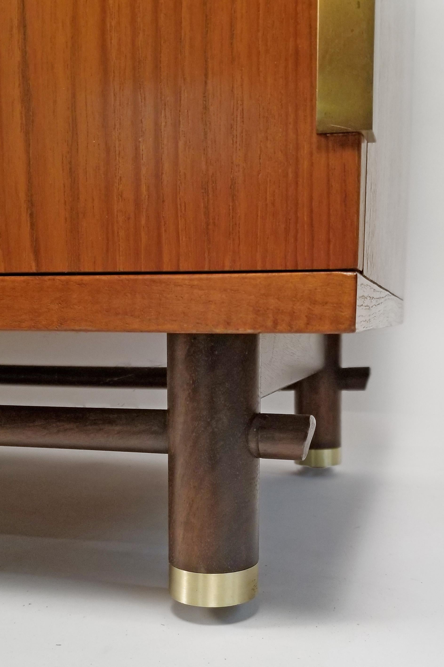 Credenza / sideboard designed by Michael Taylor for the Far East collection manufactured by Baker. The credenza is in excellent original condition constructed with beached mahogany case, walnut legs with solid brass hardware. Dining table and eight