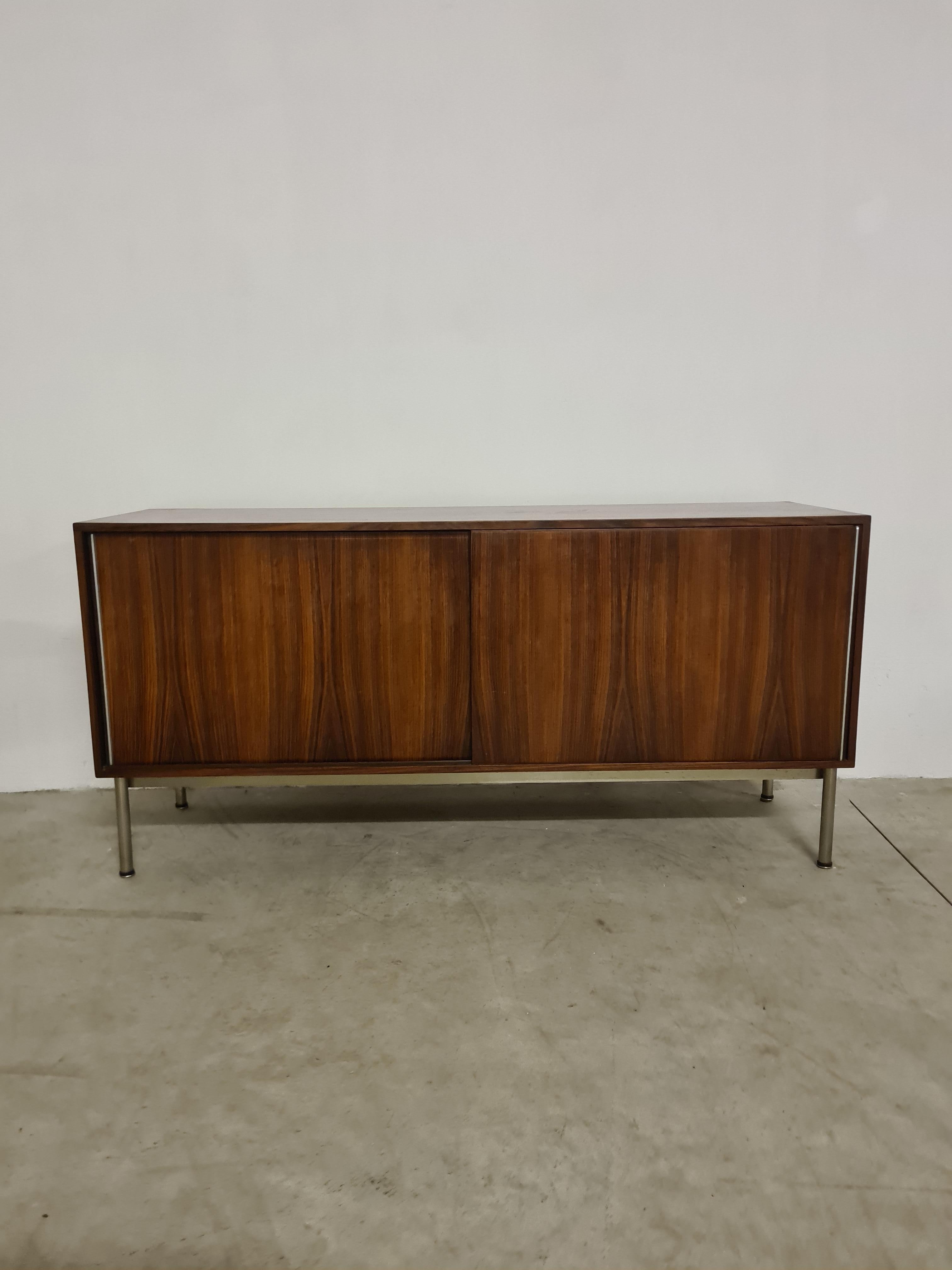 1970s sideboard by Gastone Rinaldi for Rima.

Minimalist sideboard with straight and essential lines.

Chrome-plated tubular steel legs, wood veneer body with two sliding doors via steel edging.

Internally, the sideboard features on the right, 4