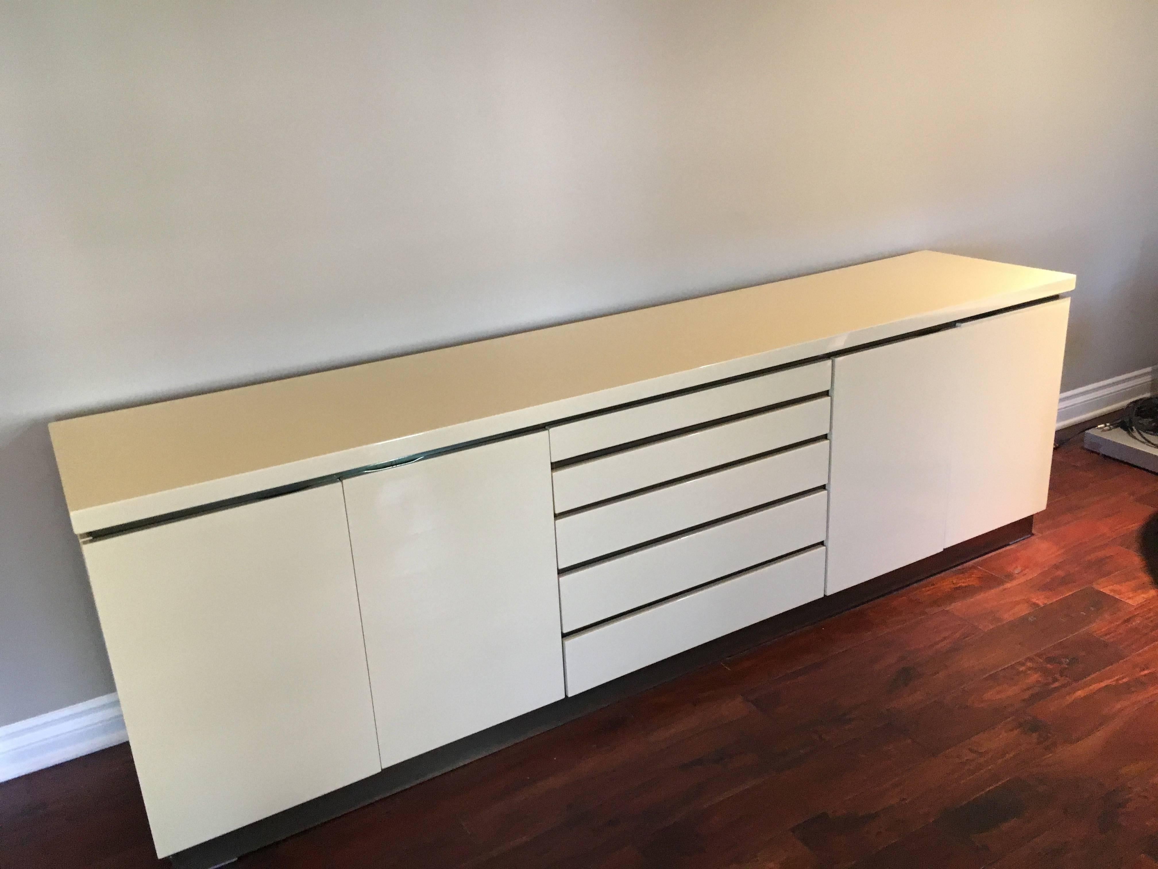 Credenza dresser in the Manner of Pierre Cardin - a lovely bone lacquered cabinet with 5 drawers center and two shelves behind doors on opposing sides of drawers. The piece could easily work as a dresser or a console or credenza - for entertainment