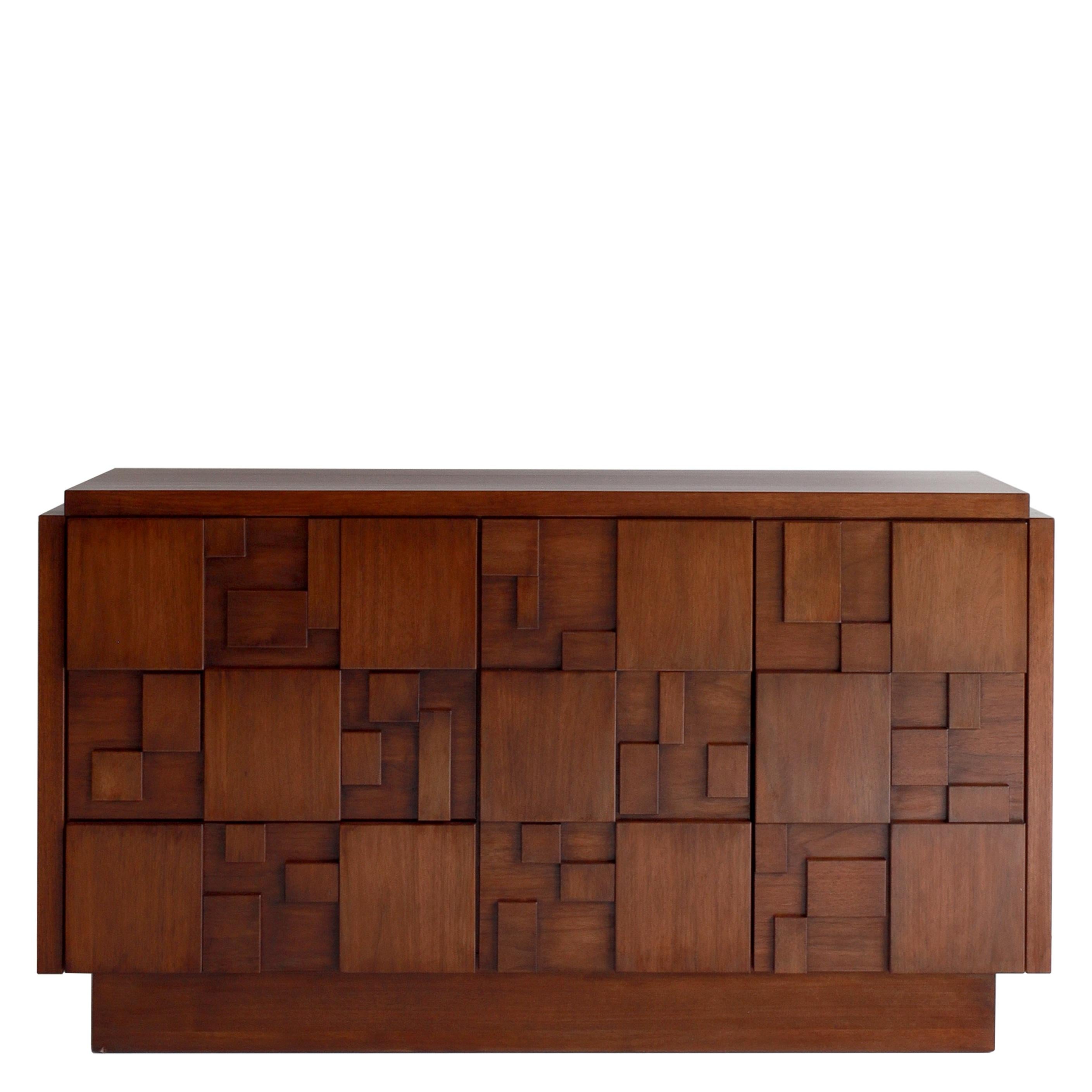 Part of The Modernist Collection, inspired by the work of American-born furniture designer, sculptor, and artist Paul Evans, this credenza reflects the true essence of the brutalist style. 

Made with varied blocks of wood attached to the front, it