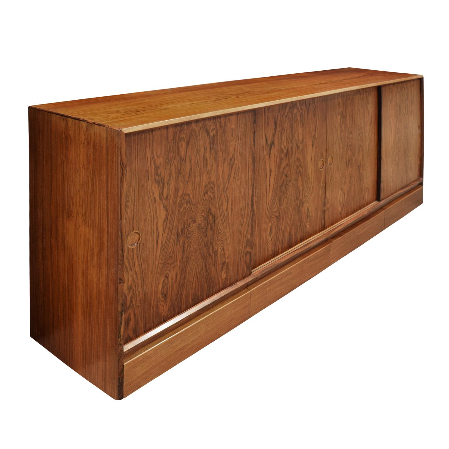 Beautifully made credenza in Brazilian rosewood, 4 sliding doors with 4 drawers below, with hand carved inset pulls by Henning Kjærnulf for V&S, Denmark 1960s (signed “V&S Made in Denmark” on back). This piece is beautifully outfitted with felt