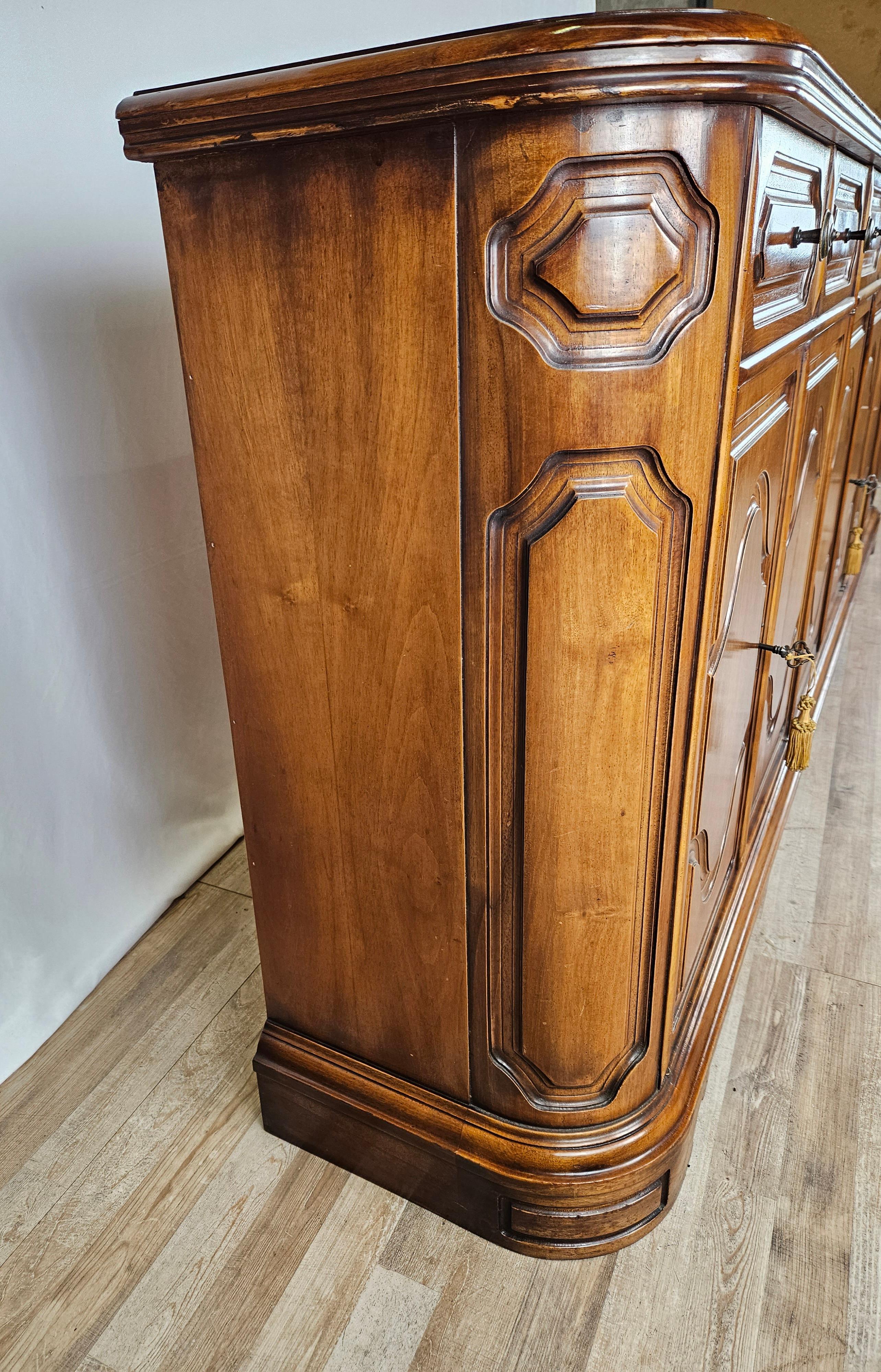 Large hall or kitchen sideboard with carved work along the doors and frame.

Early 1960s/70s wooden cabinet with as many as six drawers and six large doors with interior shelves.

The sideboard can be accompanied by modern furniture,  shabby or goes