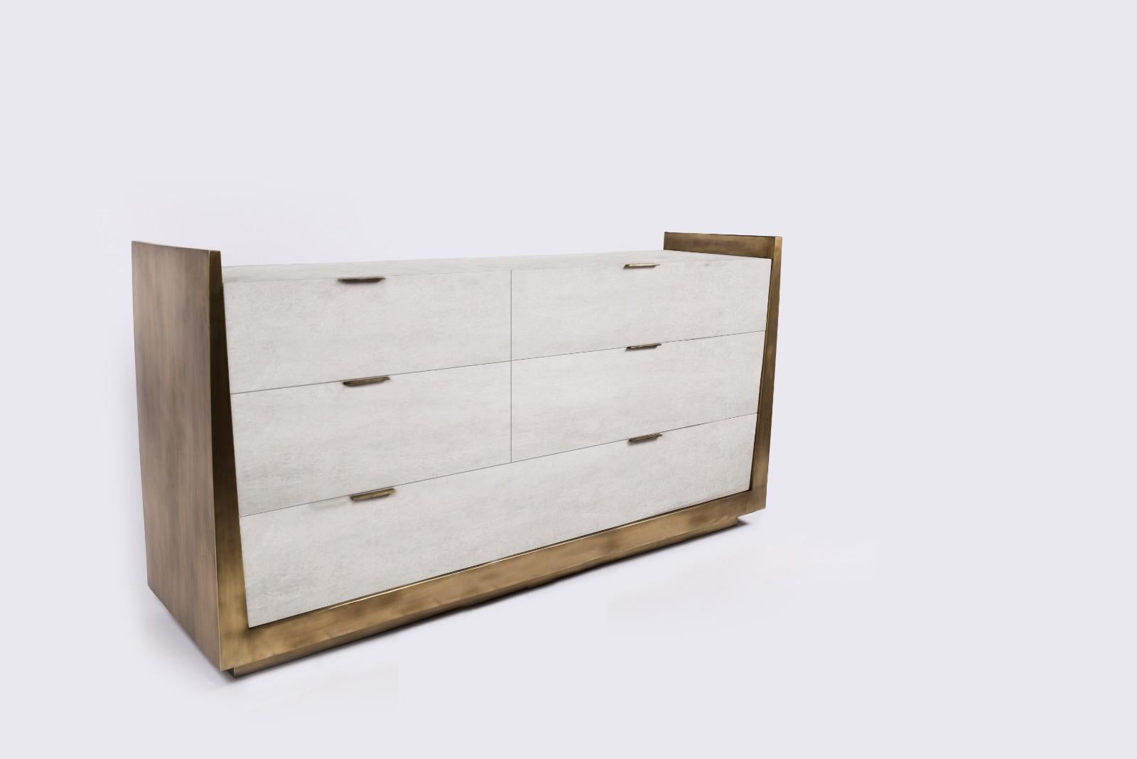 The Lola Credenza by R&Y Augousti is an elegant piece with its subtle geometry. This case storage is inlaid in cream parchment, with the sides completely inlaid in bronze-patina brass. The piece is finished off with discreet bronze-patina brass flat